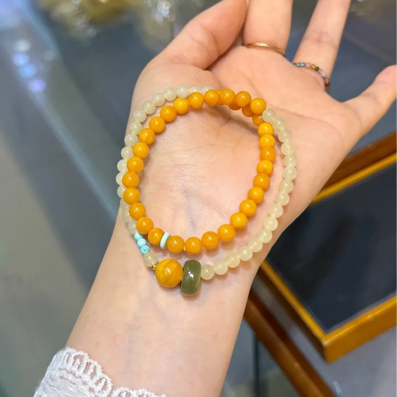 Natural Russian amber a chicken-yellow hue paired with Hetian jade in a double-strand bracelet size 5 to 6 millimeters