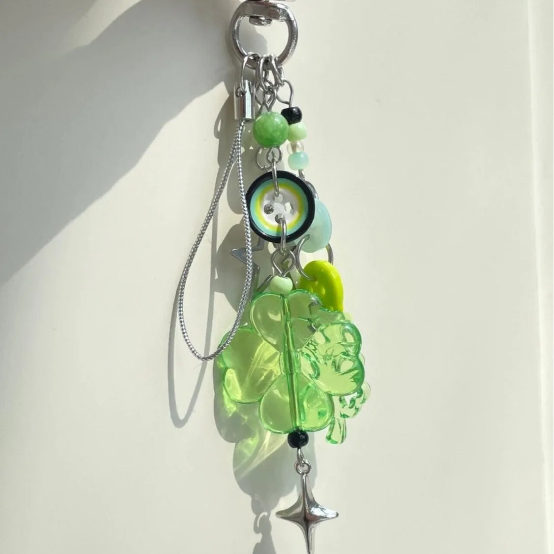 سلسلة مفاتيح صغيرة مصنوعة يدويًا بأربع أوراق البرسيم مطرزة بسلسلة كاميرا صغيرة معلقة لطيفة للهاتف المحمول