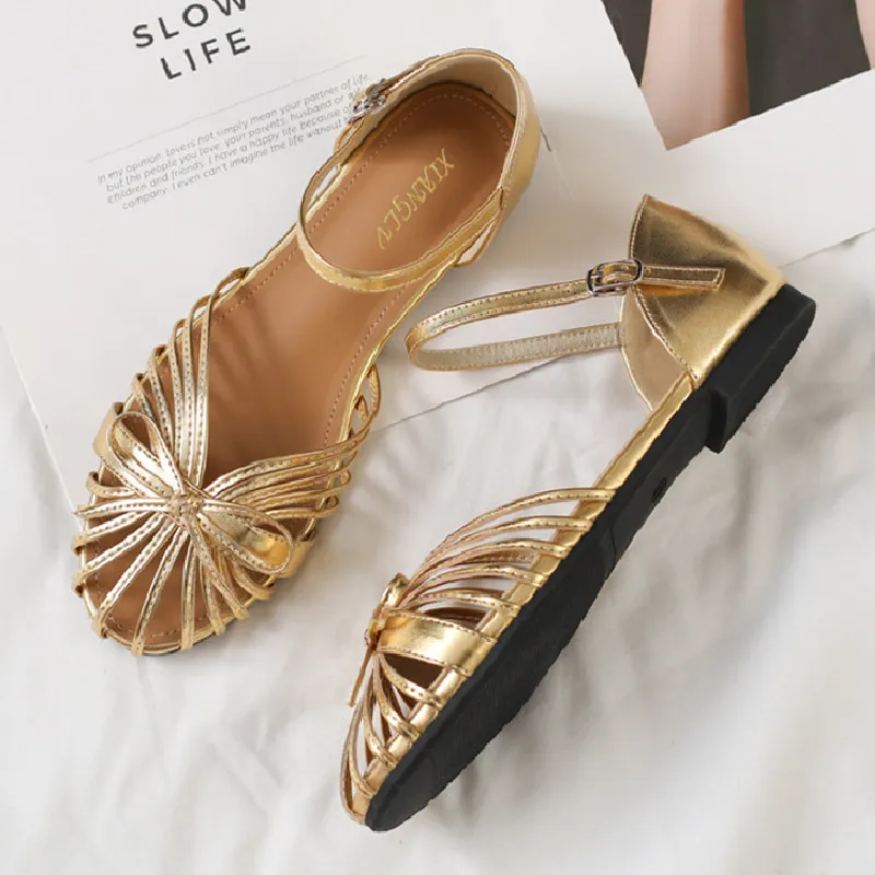 

Золотые полые сандалии на плоской подошве с узким ремешком, женские элегантные туфли-лодочки на низком каблуке с украшением в виде банта, модные пляжные туфли на плоской подошве с круглым носком и пряжкой на щиколотке