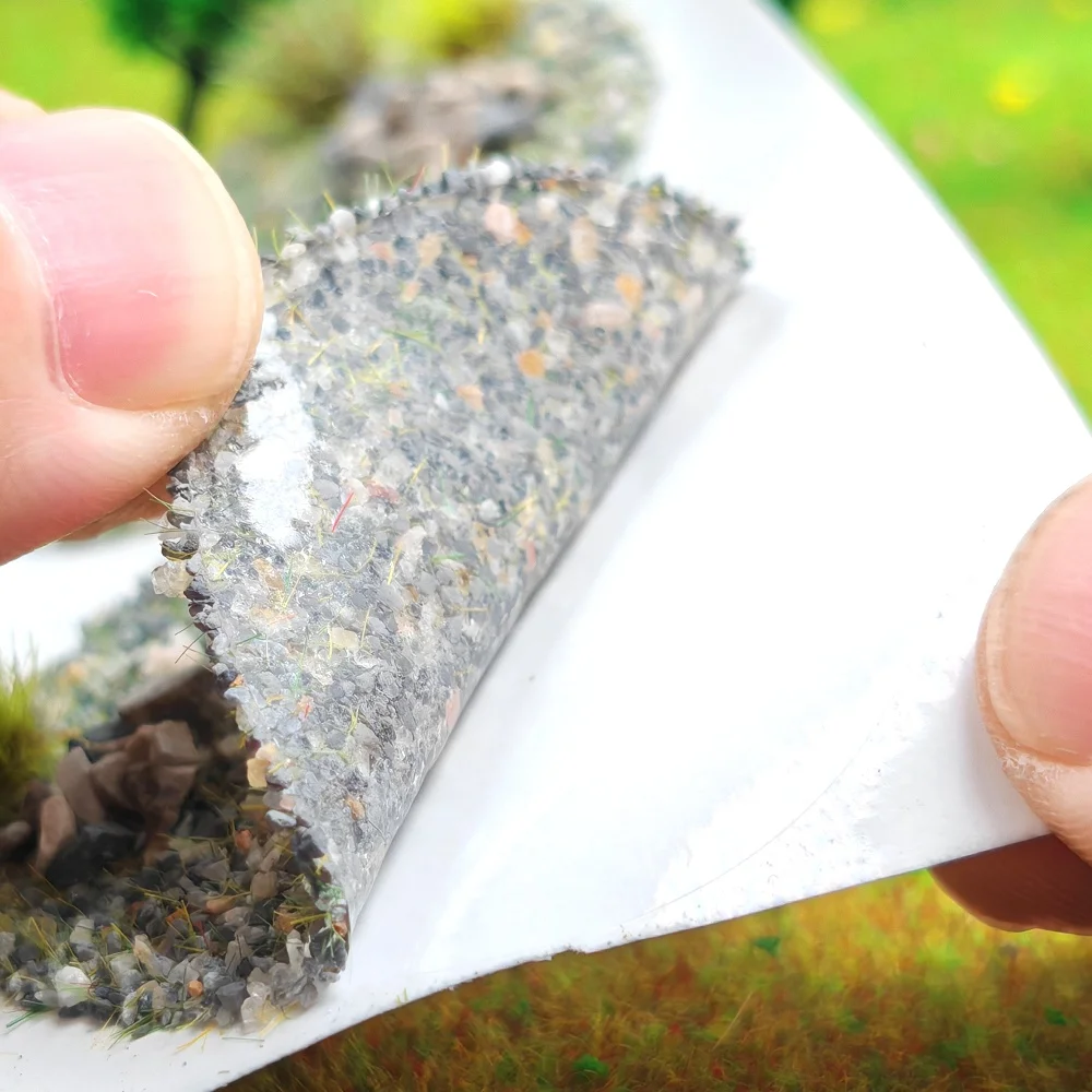 Finished grass‑rock terrain patch, miniature sandbox wilderness ground, self‑adhesive backing, tear‑and‑stick application
