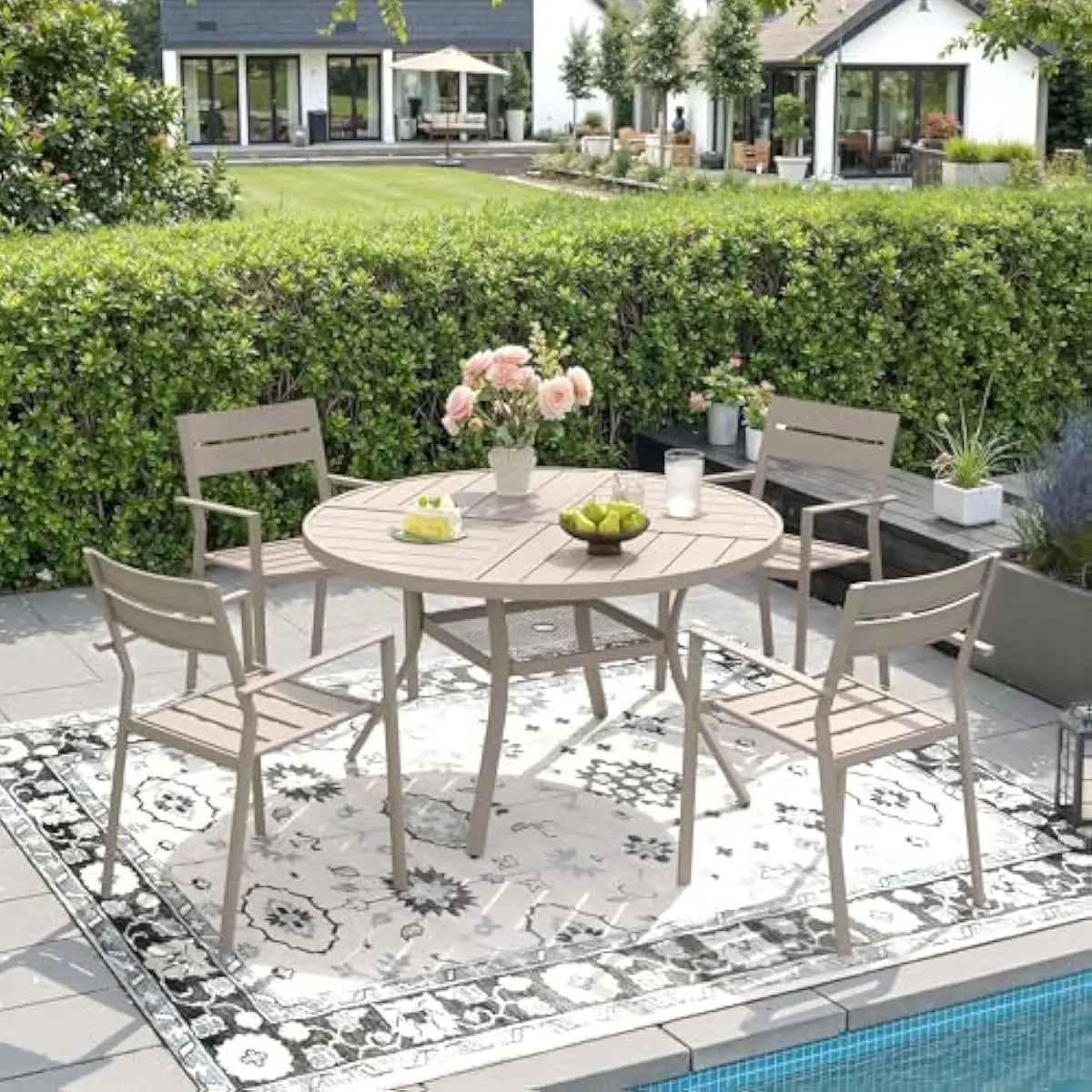 Outdoor dining ensemble for four persons featuring round metal table with integrated umbrella aperture and four ergonomic stacka