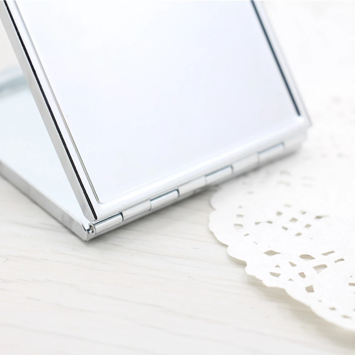 Kompaktowe lusterko kwadratowe, lekkie, składane, z powierzchnią o wysokiej rozdzielczości, do noszenia w torebce lub kieszeni.