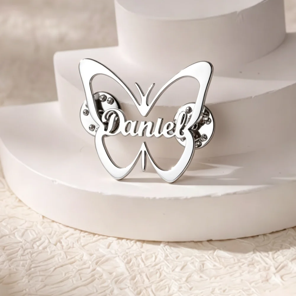 Custom golden hollow butterfly name brooch engraved with Daniel, elegant personalized lapel pin for outfit decoration and gift.