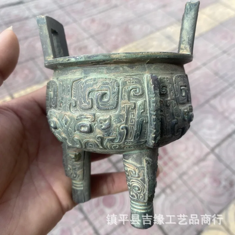 Round bronze-colored, antique-style, double-eared, three-legged, relief-decorated incense burner, a handcrafted alloy piece rese