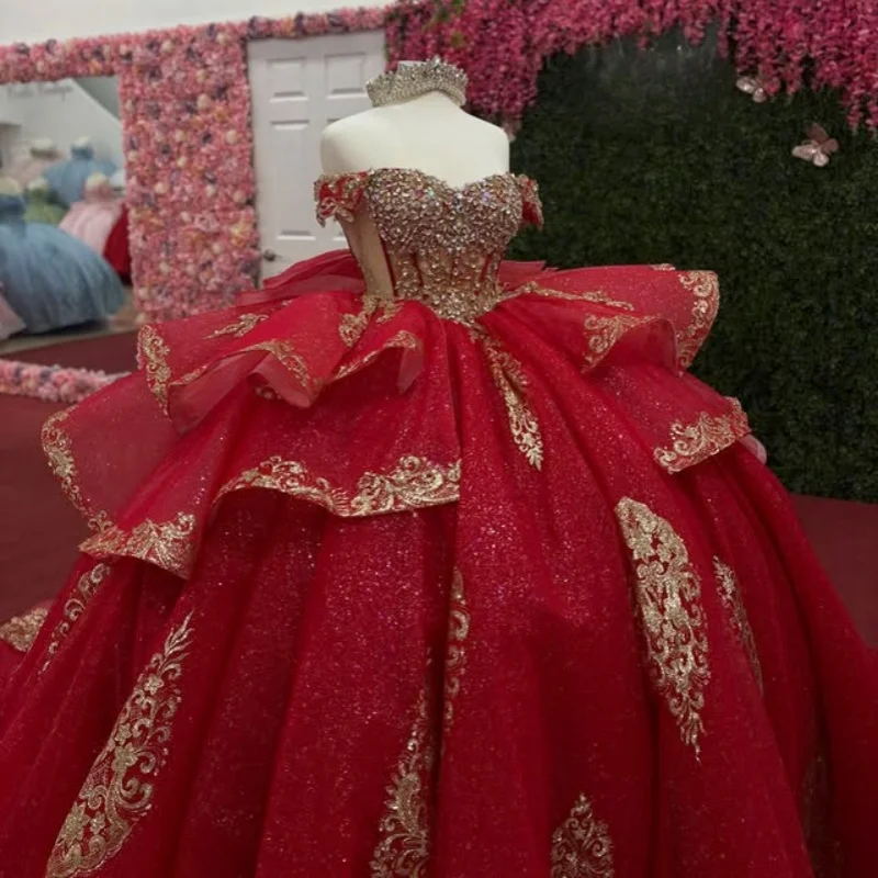 

Блестящее красное платье для квинсеаньеры с открытыми плечами, золотистыми блестками, кружевными вставками, многослойным длинным шлейфом и бантом. Индивидуальный пошив.