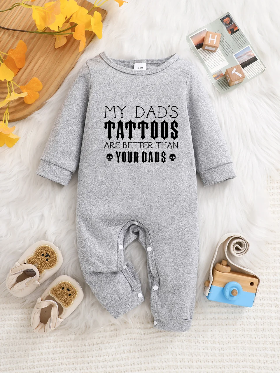 A baby long-sleeved onesie with interesting letter prints. It features a buttoned design for easy putting on and taking off, and