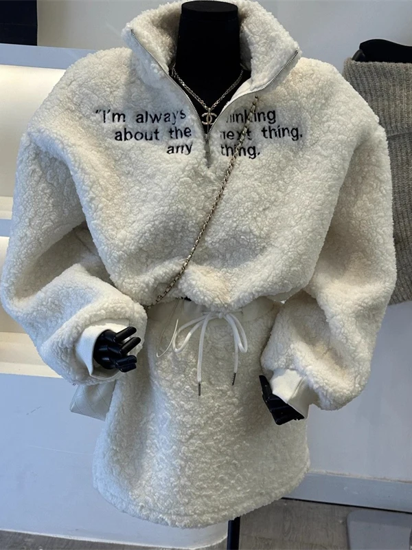 

Теплый повседневный комплект из двух предметов: свитшот с вышивкой и высоким воротником на молнии, и короткая юбка из овечьей шерсти. Модный зимний наряд.