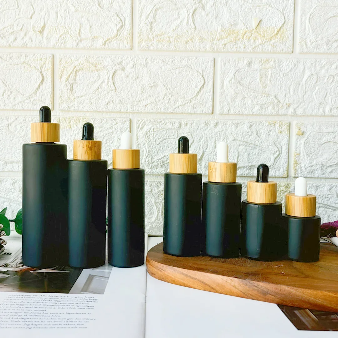 Botella cuentagotas de vidrio negro mate vacía, pedido a granel, aceites esenciales recargables de madera amboo, contenedores para el cuidado de la piel con tapa de bambú