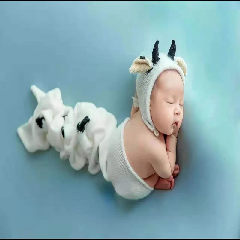 Newborn Baby with A Full Moon for 100 Days Takes Pictures of A Cow-shaped Hat Wrapped In A Cloth Towel.