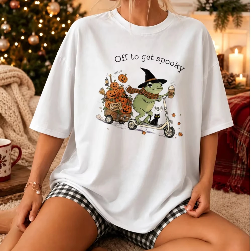 Off To Get Spooky Graphic T‑Shirt Halloween Witch Frog Riding Scooter with Pumpkins Cart Black Cat Coffee Drink Fall Casual Tops