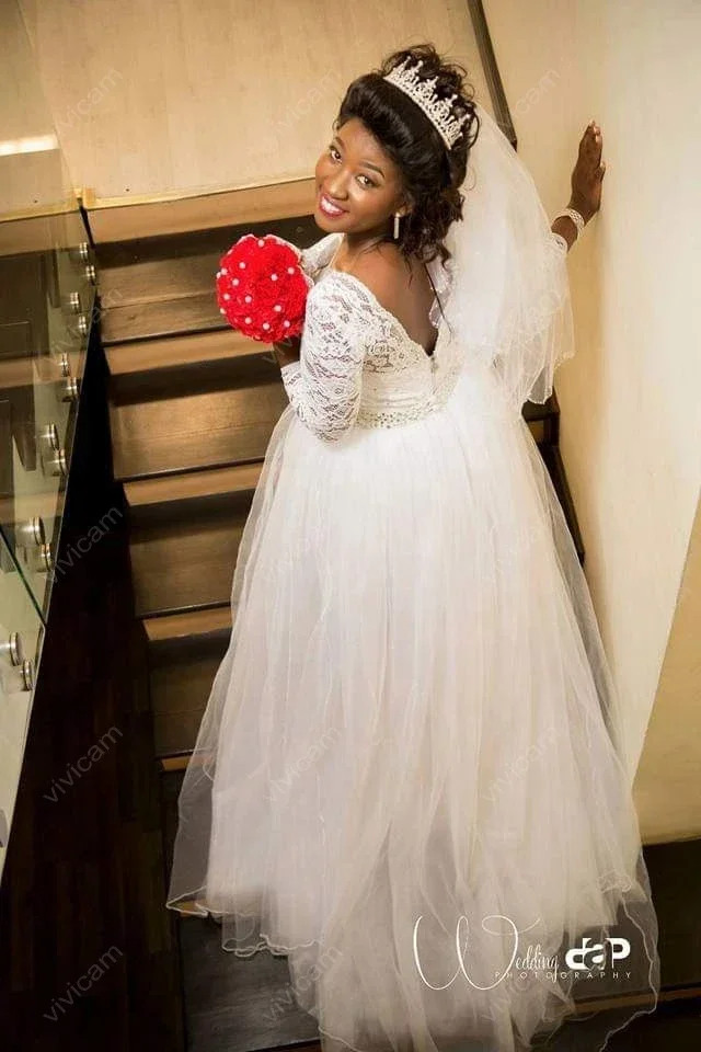 Suknie ślubne z koronką, dekoltem w łódkę, długimi rękawami, odpinanym trenem i odkrytymi plecami, zdobione uroczy, personalizowane kryształki.