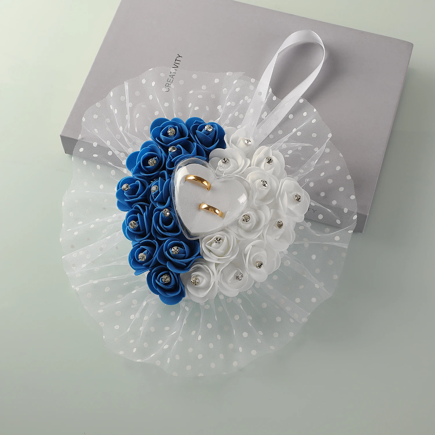 

A wedding ring pillow decorated with a bright azure color for a banquet.