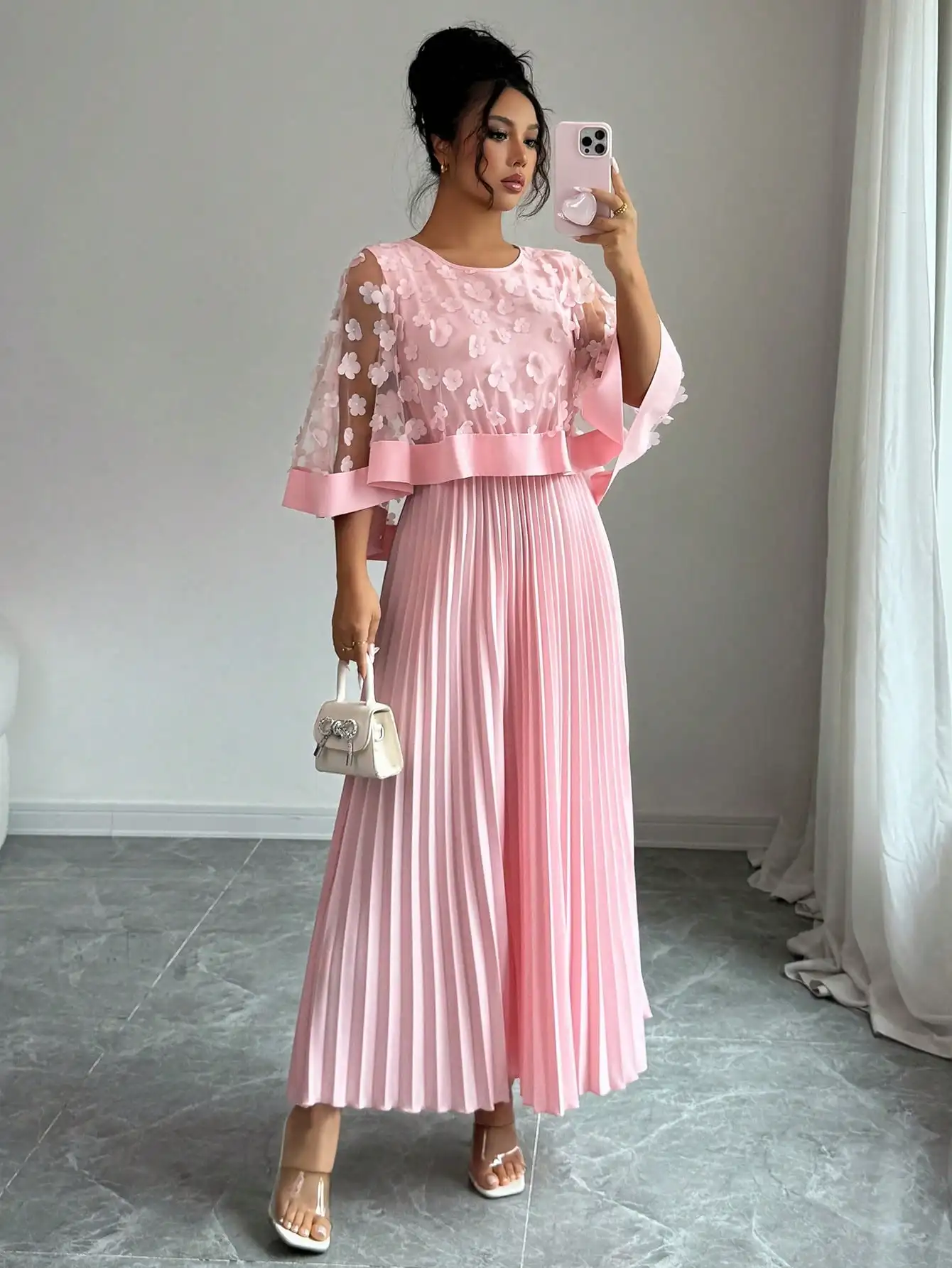 

Розовое плиссированное платье макси с цветочным аппликационным декором, поясом из лент и рукавами-колокол.
