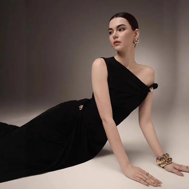 BEWQ فستان نسائي أنيق برقبة مائلة بدون أكمام محبوك مطوي زر معدني فستان الحفلات المسائية 2025 خريف جديد