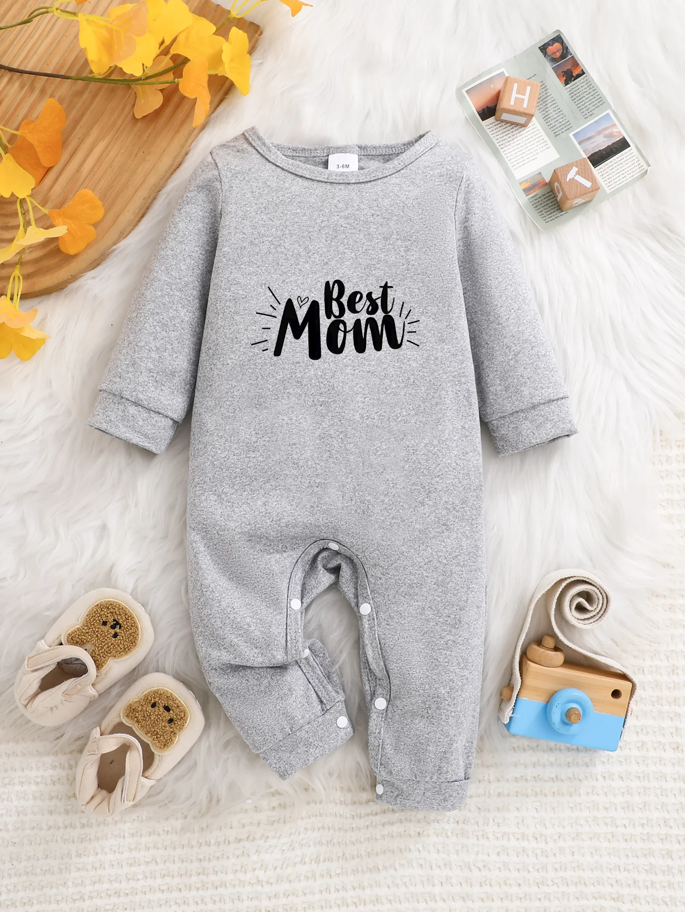 A baby long-sleeved onesie with interesting letter prints. It features a buttoned design for easy putting on and taking off