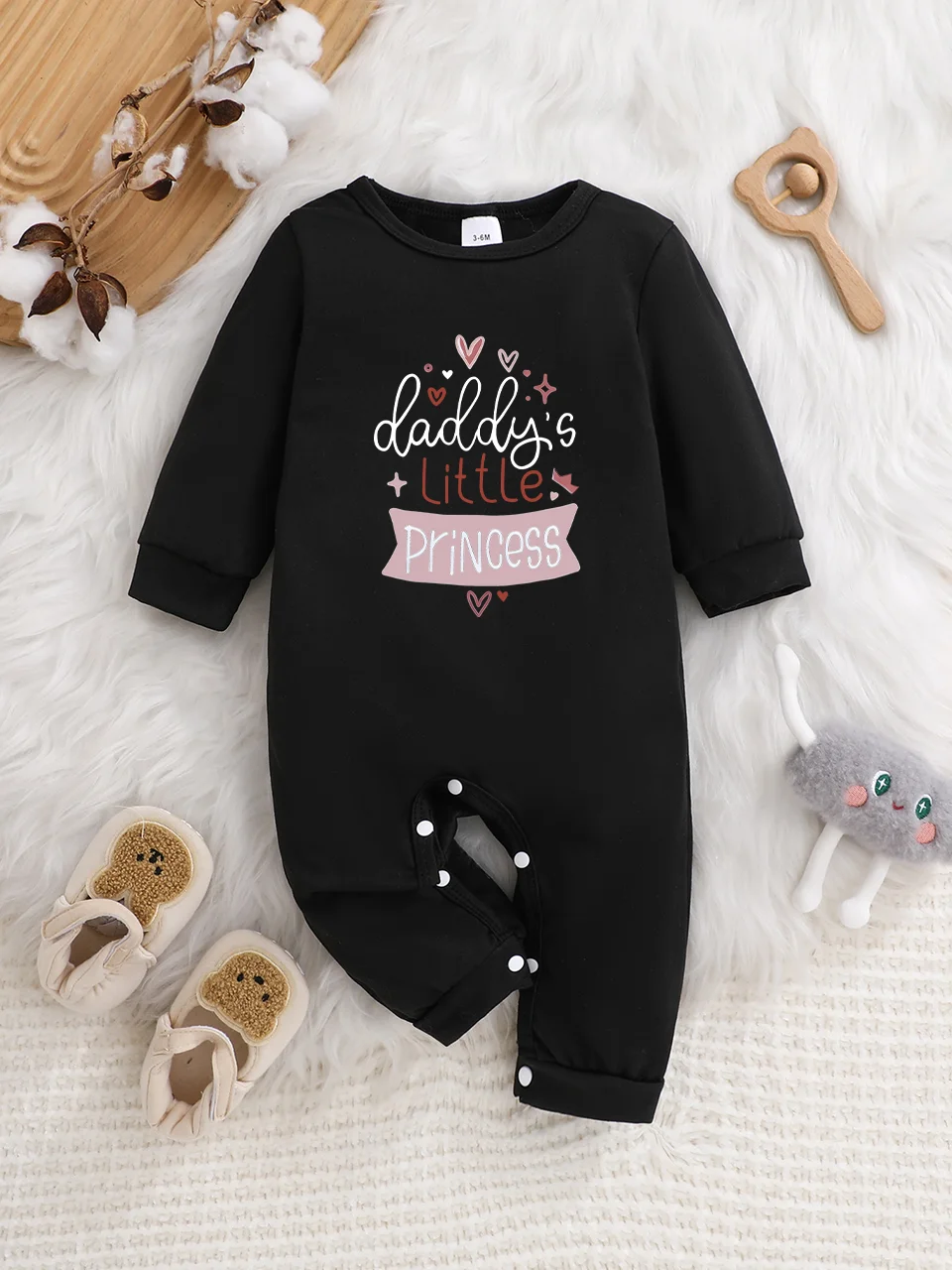 Ein langärmeliger Baby-Strampler mit interessanten Buchstaben-Prints. Es verfügt über ein Knopfverschluss-Design für einfaches An- und Ausziehen.