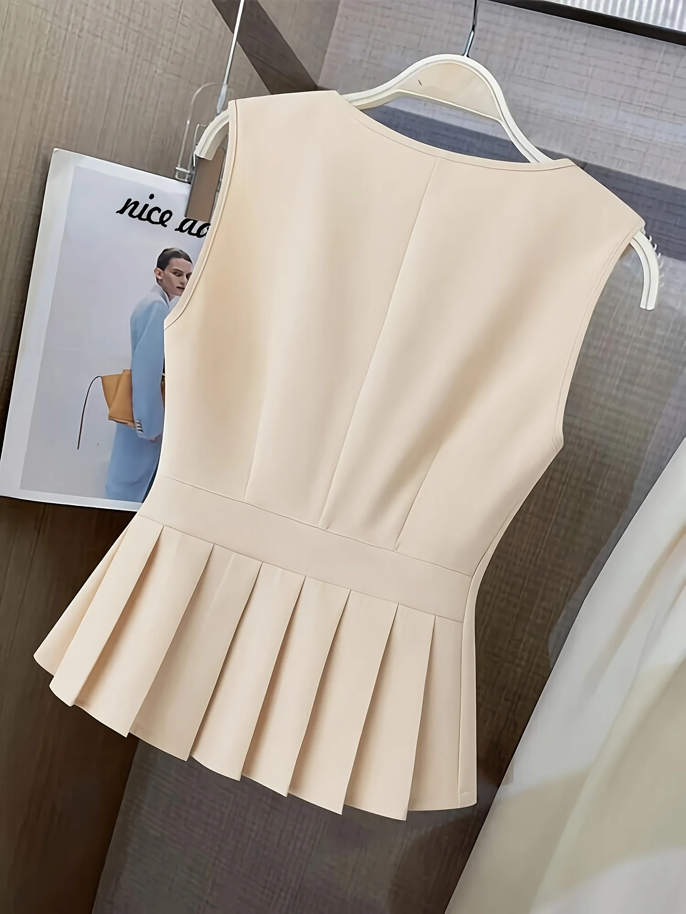 Women’s clothing featuring a V-neck, sleeveless design with pleats at the hem. Perfect for casual or professional settings with
