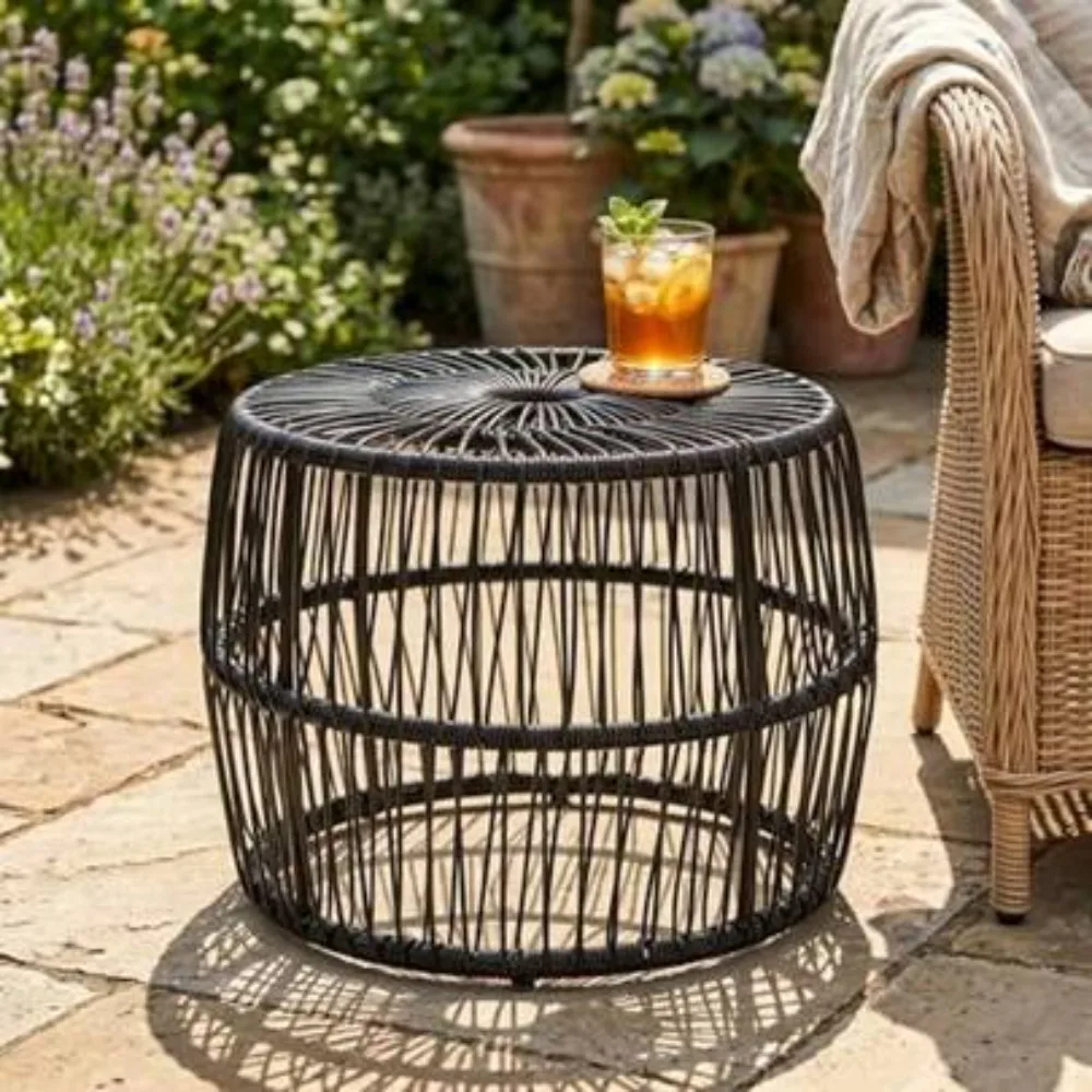 Kuro Black All-Weather Woven Rattan Drum Table centered on a minimalist stone patio courtyard