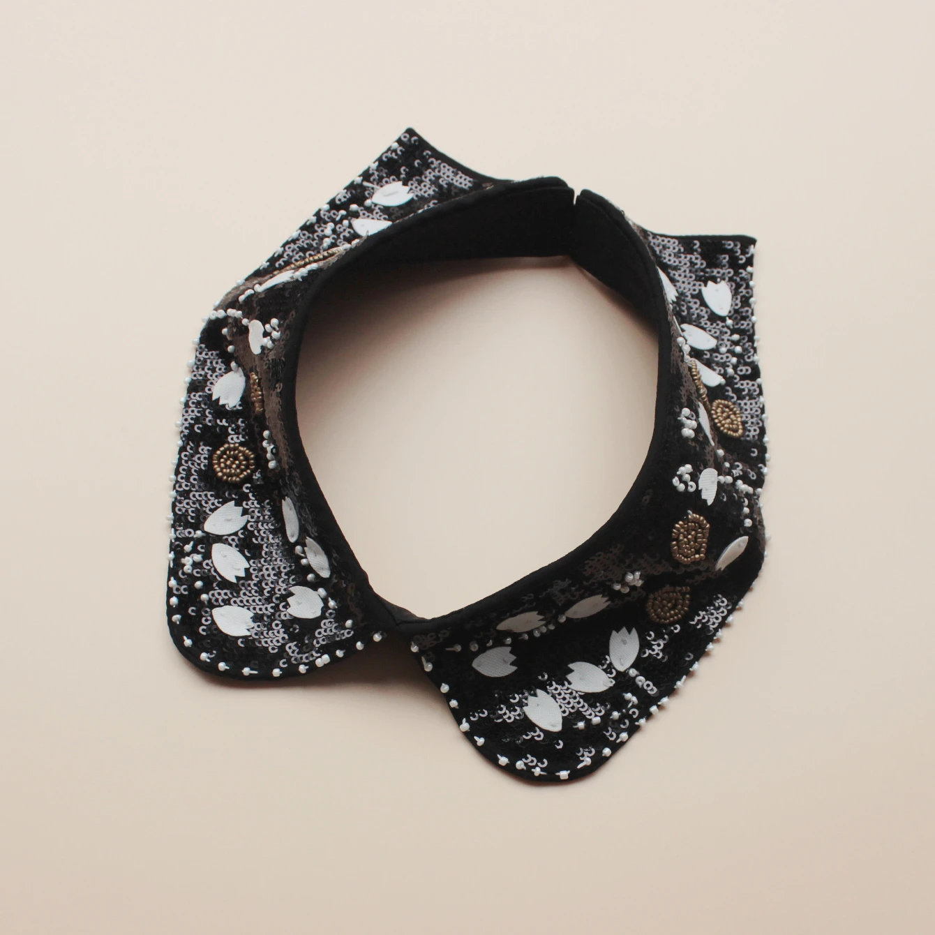 Fashion accessory, luxurious sequined false collar. Classic black background with white flowers. Inlaid with shining bead orname