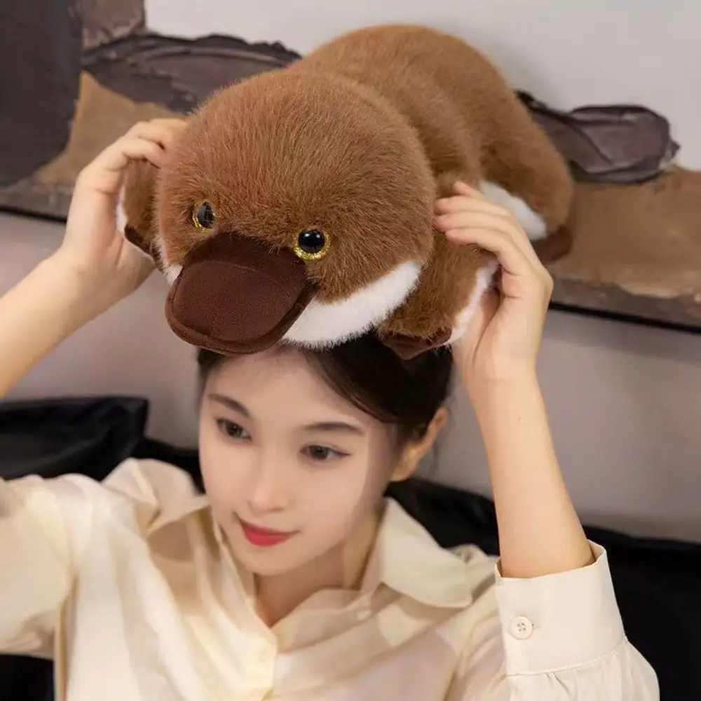 

Супермягкая плюшевая подушка-игрушка в виде утконосца, коричневая, в позе лежа на животе, имитация утконоса, пушистый материал, мягкая игрушка-кукла