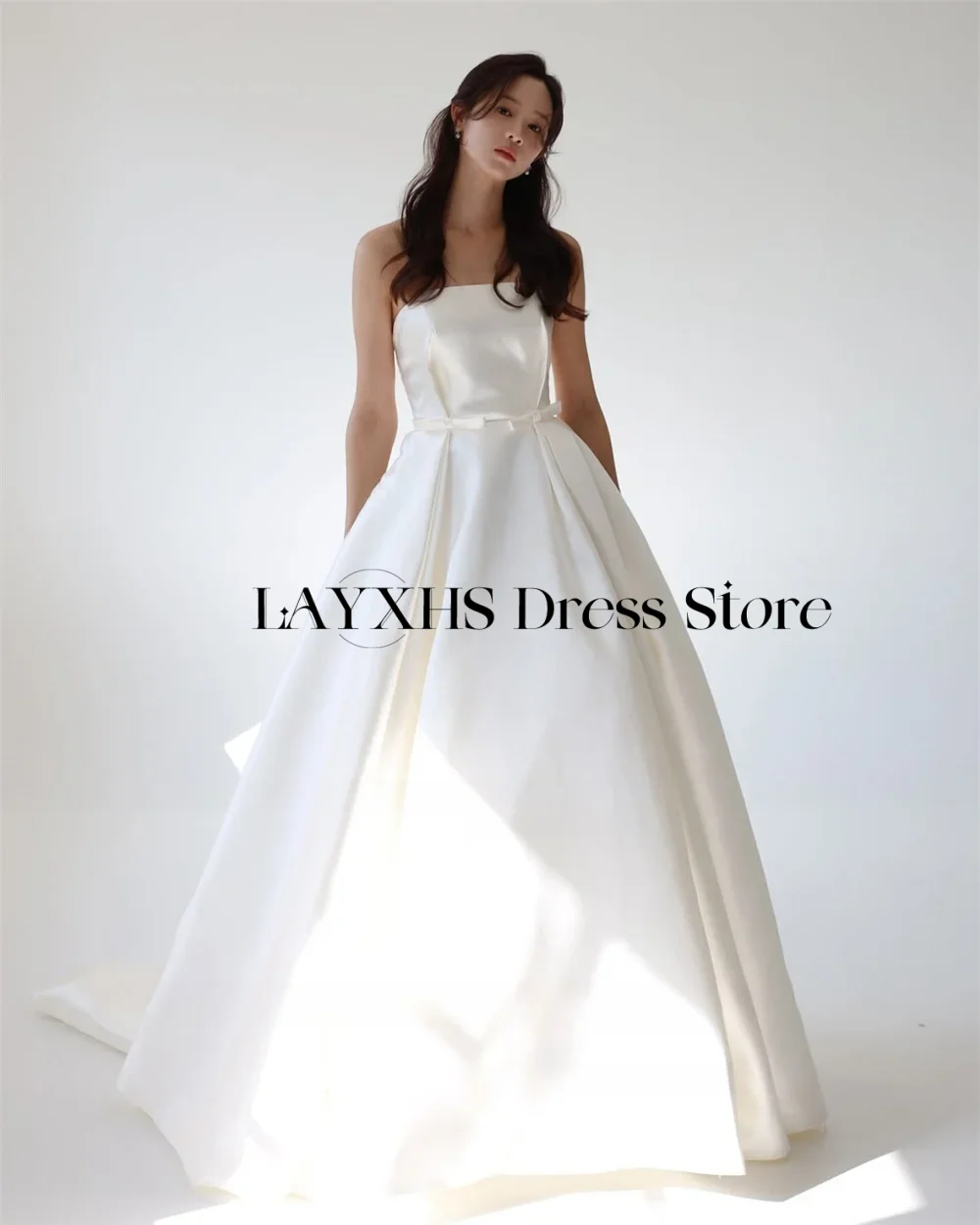 Abiti da sposa coreani eleganti senza spalline Una linea in raso Abito da sposa personalizzato Servizio fotografico Abito da sposa con corsetto con fiocco e strascico