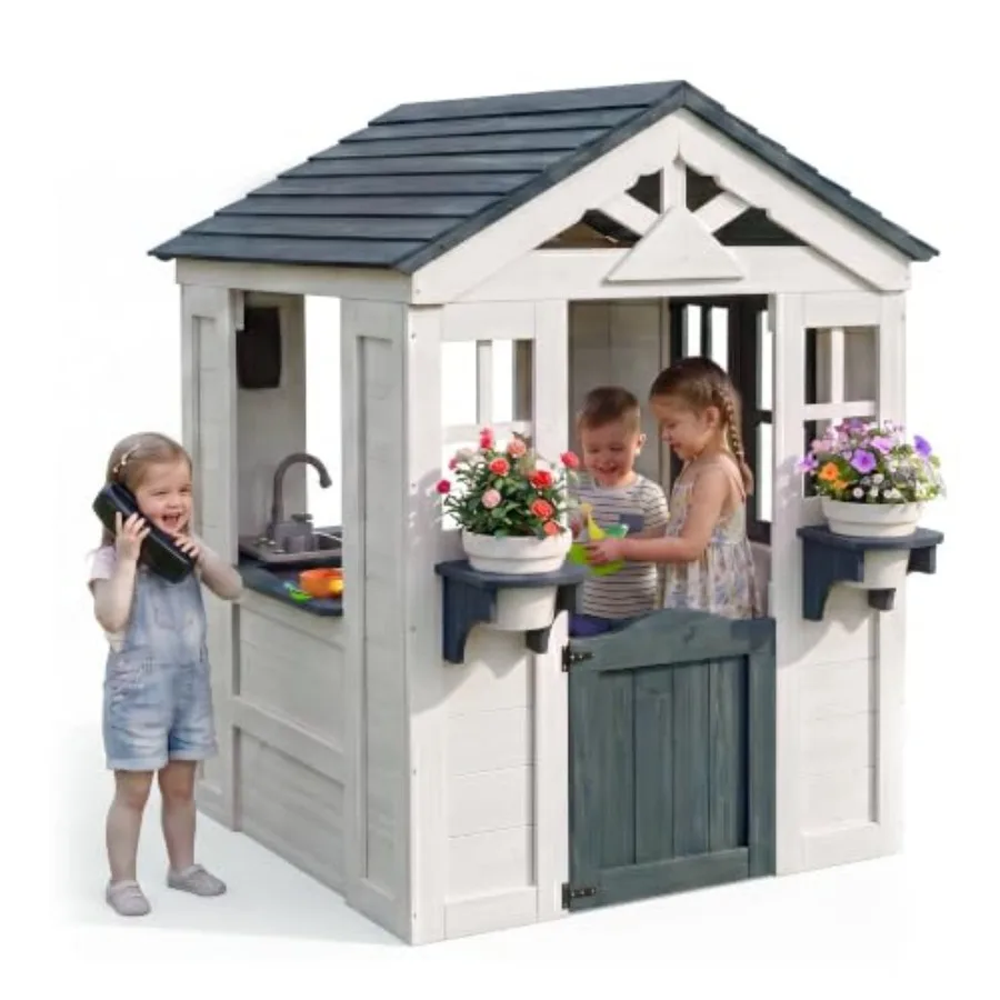 Outdoor Playhouse for backyard use, made of wood, white color, features door, windows, toy phone, flower pot shelves and kitche