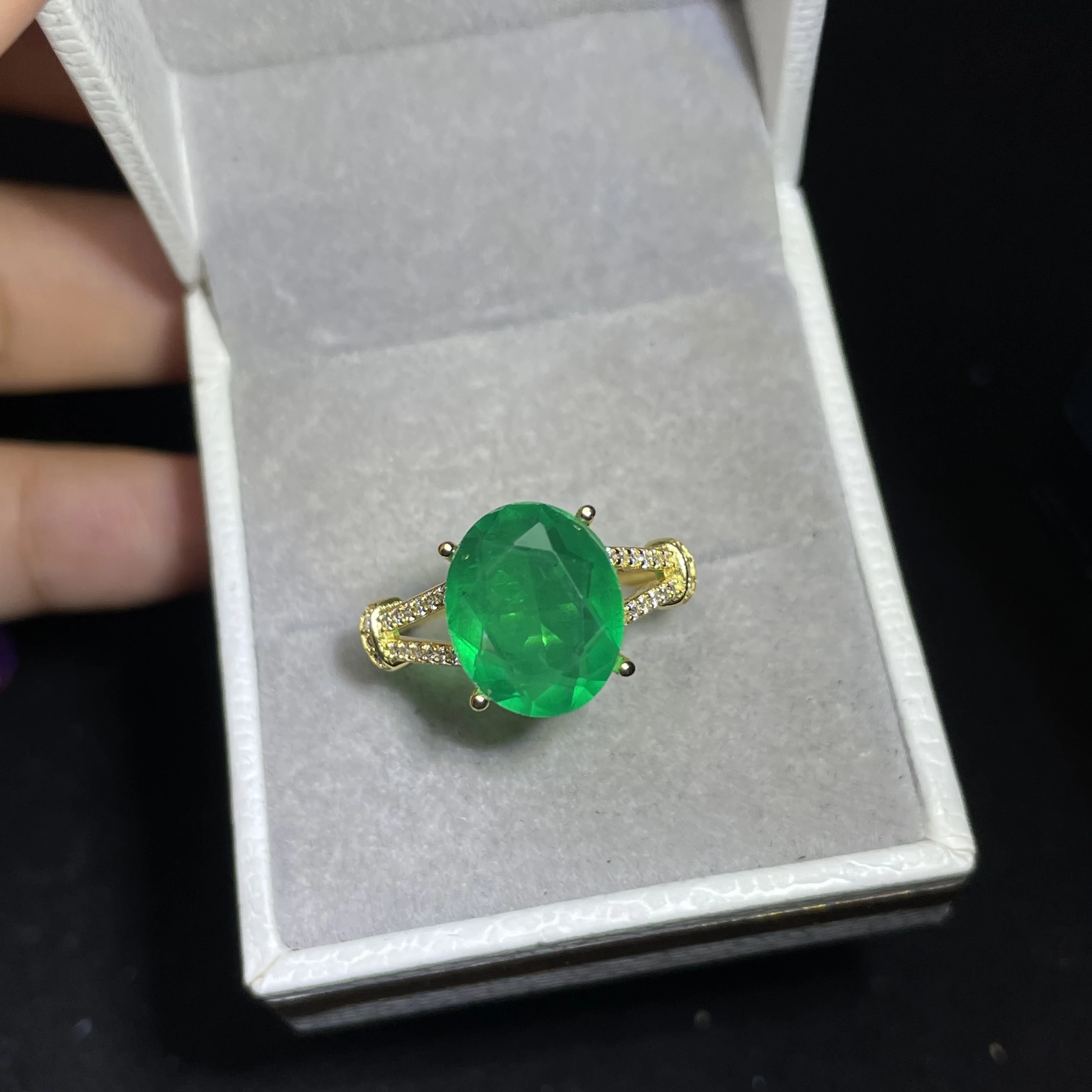 A beautiful oval emerald ring set with diamonds, suitable for the jewelry of a female bride for her wedding party