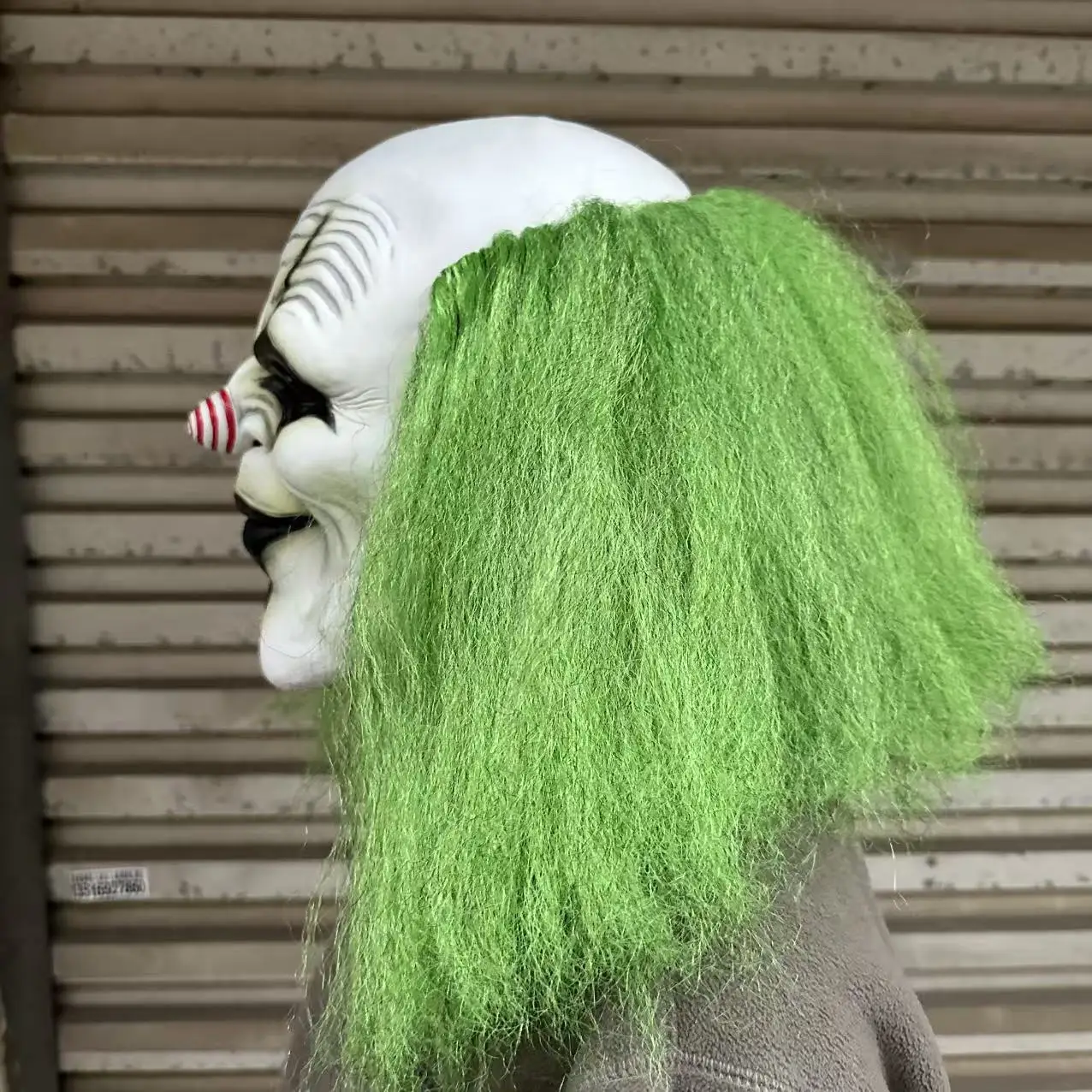 Furchteinflößender grünhaariger Clown mit Latexmaske und einer spiralförmigen rot-weißen Nase. Geeignet für Halloween-Kostümparty-Requisiten – Detail 2