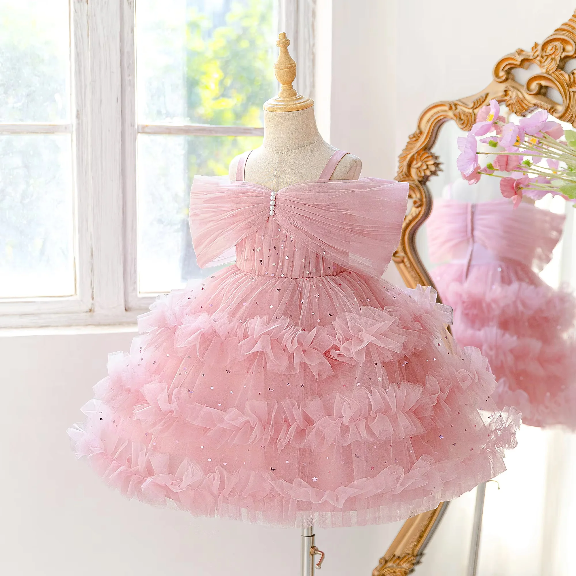 Pink kids short gown with thin spaghetti straps and bow decoration on chest. Fluffy tulle skirt looks sweet and fresh. Custom si