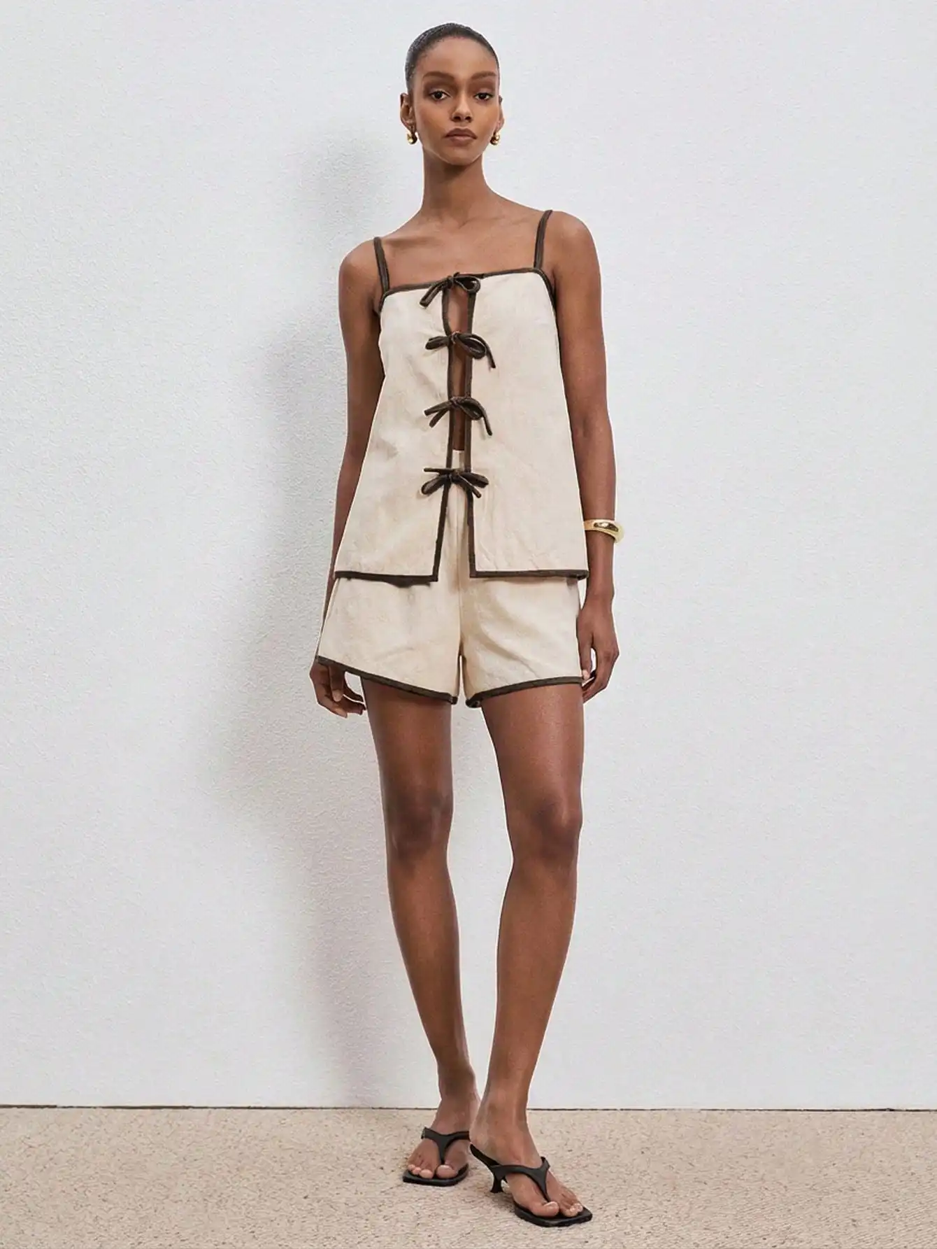 

Женский комплект из 2 предметов: летний топ-камизоль с завязками спереди и контрастной отделкой, а также подходящие шорты.