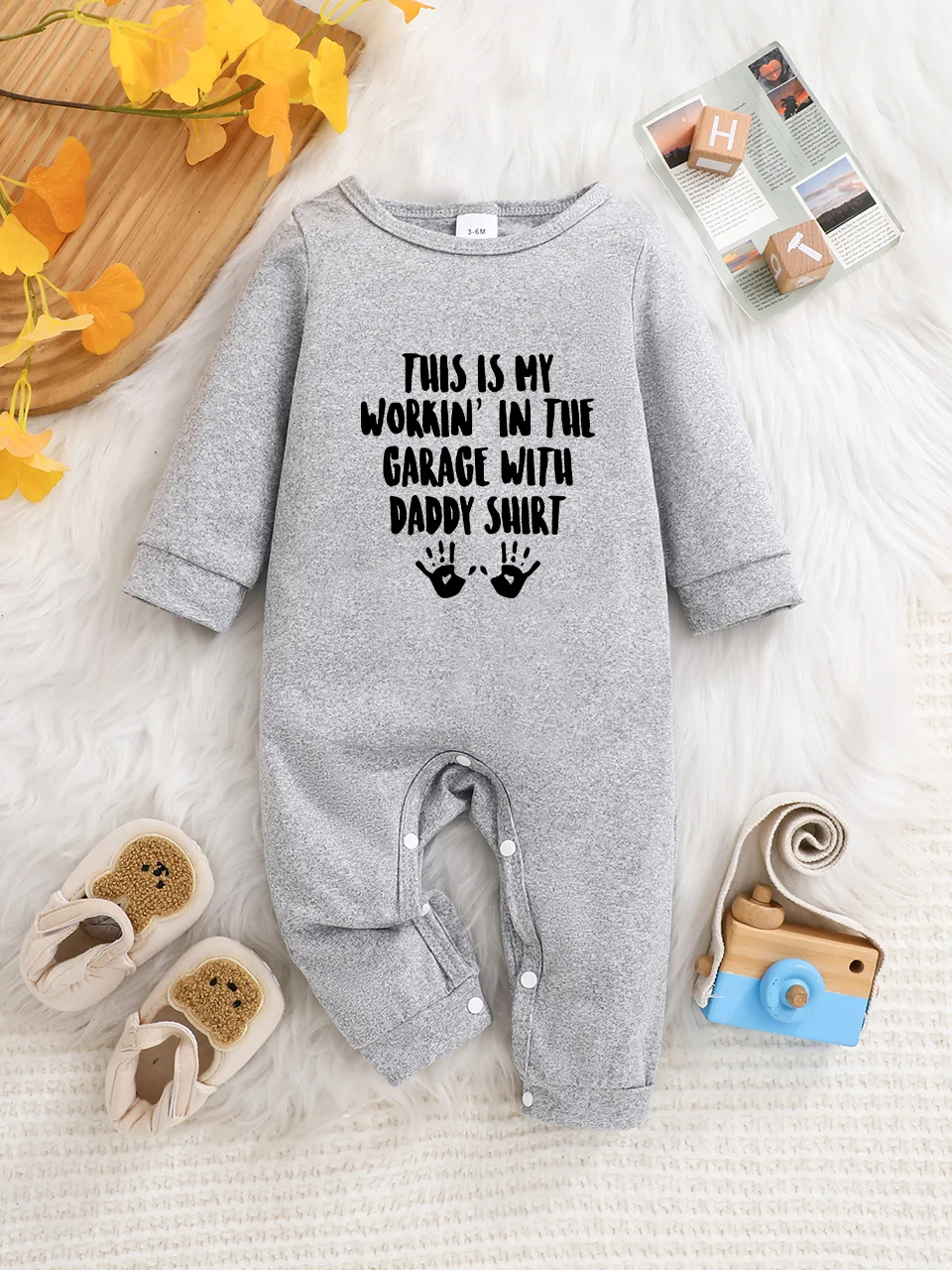 A baby long-sleeved onesie with interesting letter prints. It features a buttoned design for easy putting on and taking off