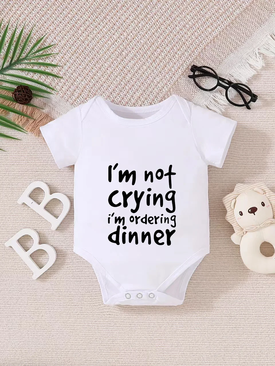 Playful letter-printed baby short-sleeve triangle bodysuit. Button closure for easy dressing, machine washable