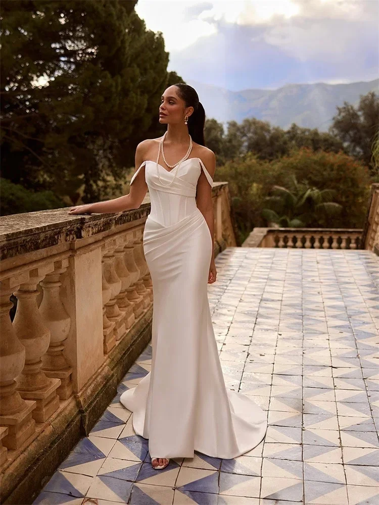Pure white sleeveless fitted floor-length gown with delicate small train. Sleeveless design flatters shoulder lines, tailored fi