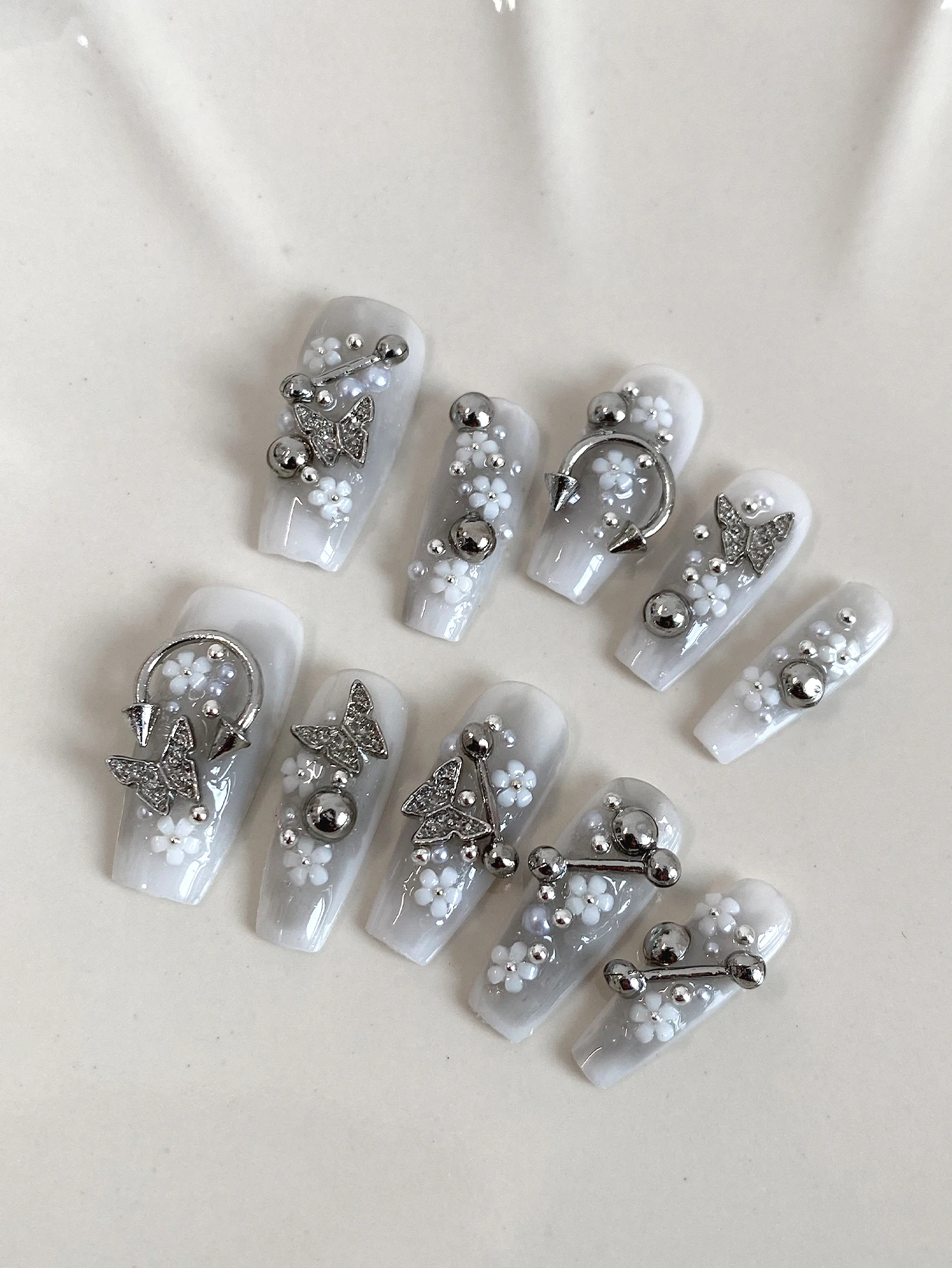 Milky White Press On Nails,Long Coffin Fake Nails with Metal Piercing Charms,Butterfly Rhinestones & Tiny White Flowers