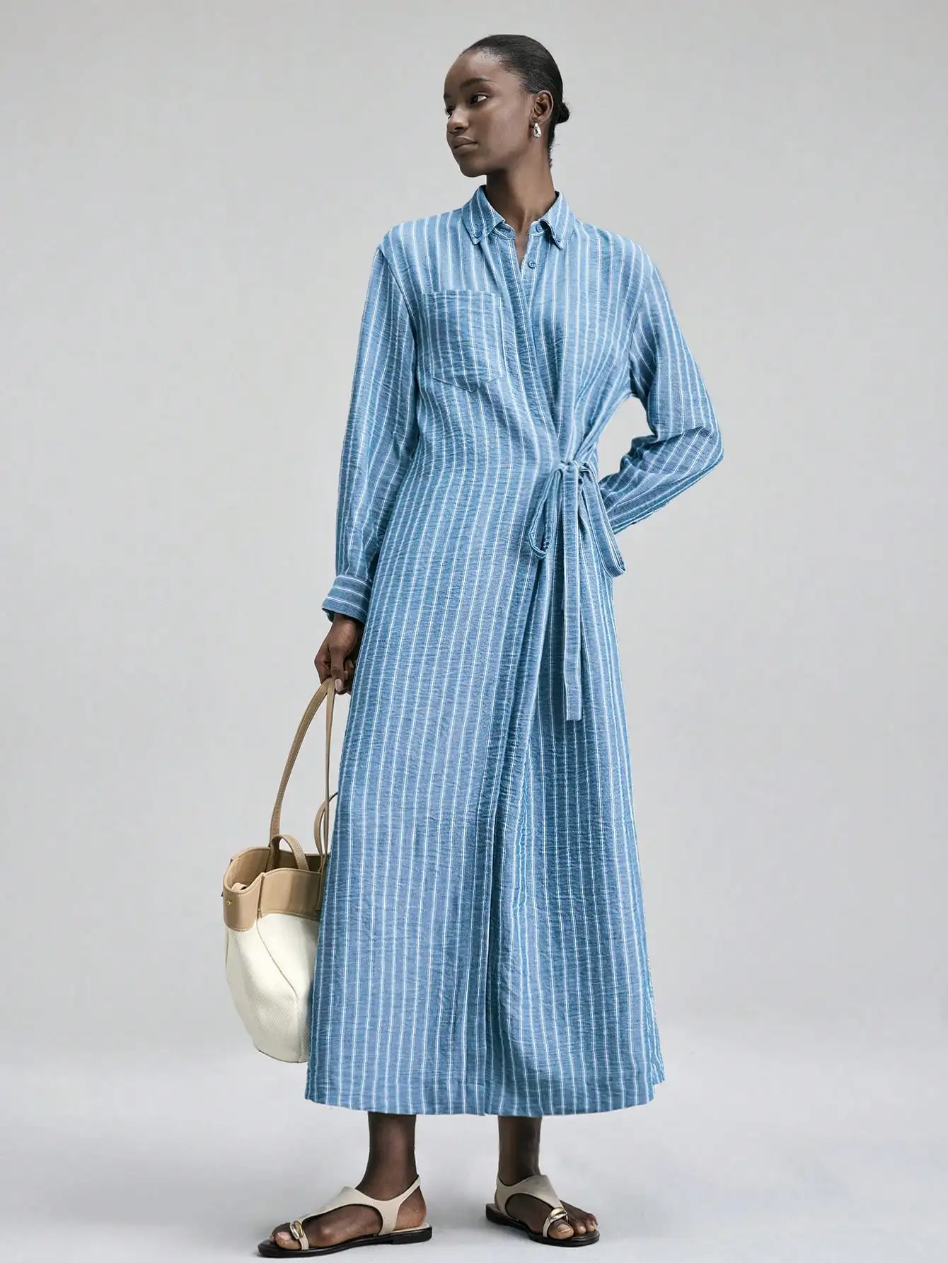 

Женское платье-рубашка в сине-белую полоску с завязкой на талии, длинными рукавами и свободным кроем