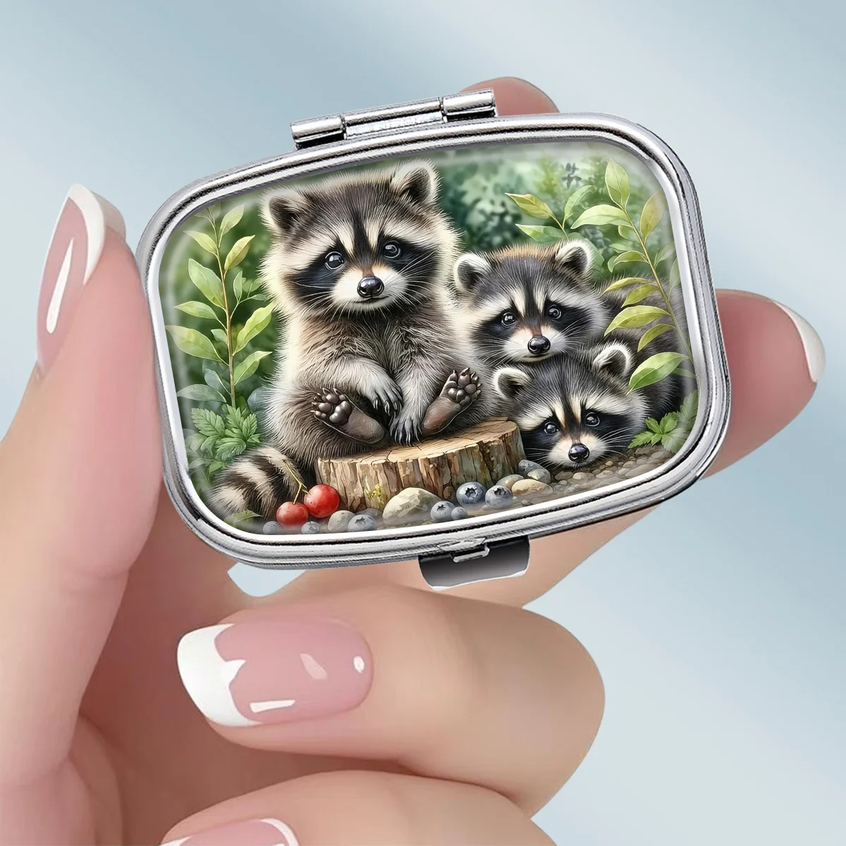 A 2D Portable Square Metal Pill Box Featuring a Cute Forest-Themed Design with a Raccoon Family, Designed with Two Compartments, Perfect for Elegantly Storing Your Medications Or Supplements. It'S Ideal for Organizing Vitamins And Keeping Small Item
