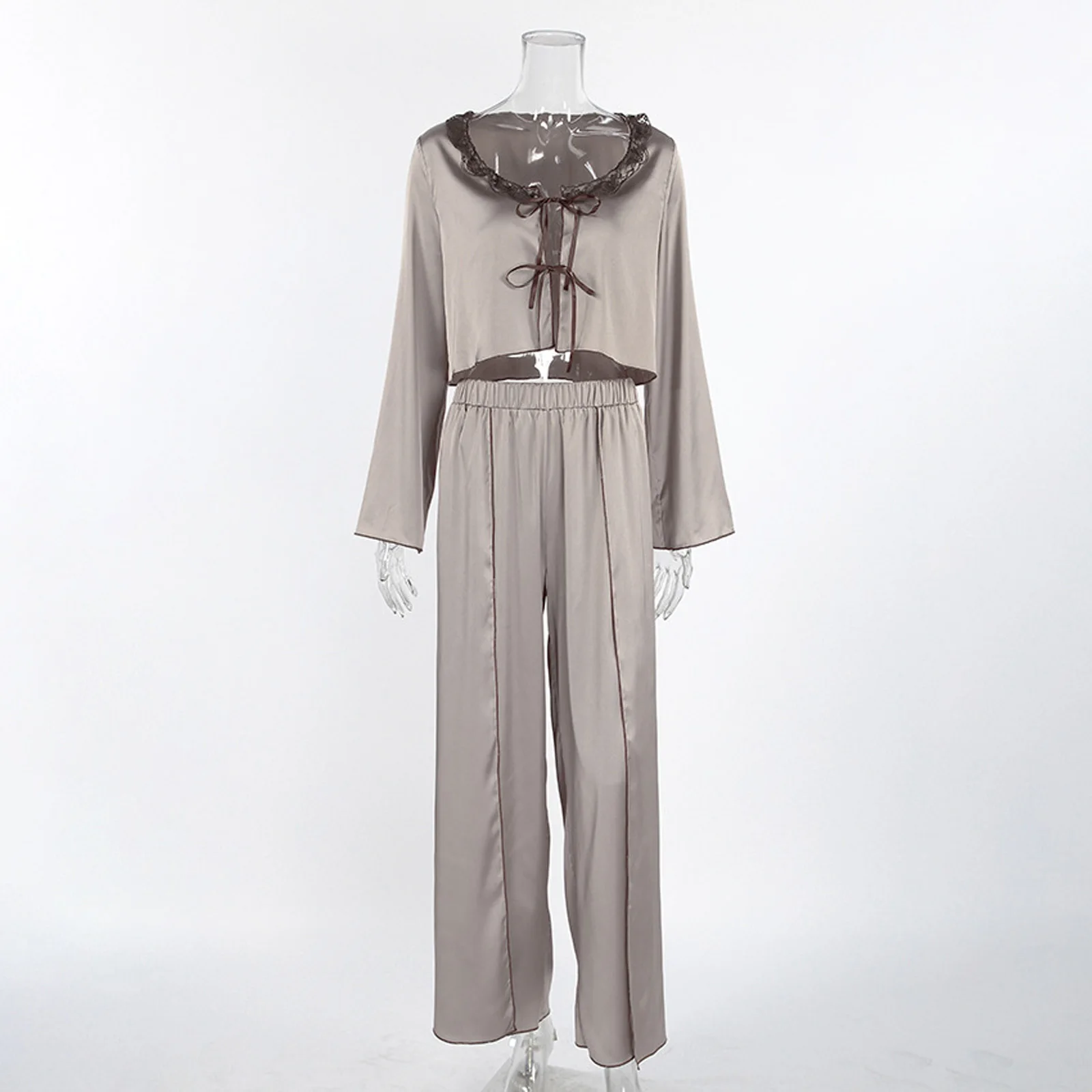 

Атласный комплект из двух предметов с рюшами: укороченный топ с длинными рукавами и расклешенная макси-юбка с высоким разрезом. Элегантный летний комплект для отдыха.