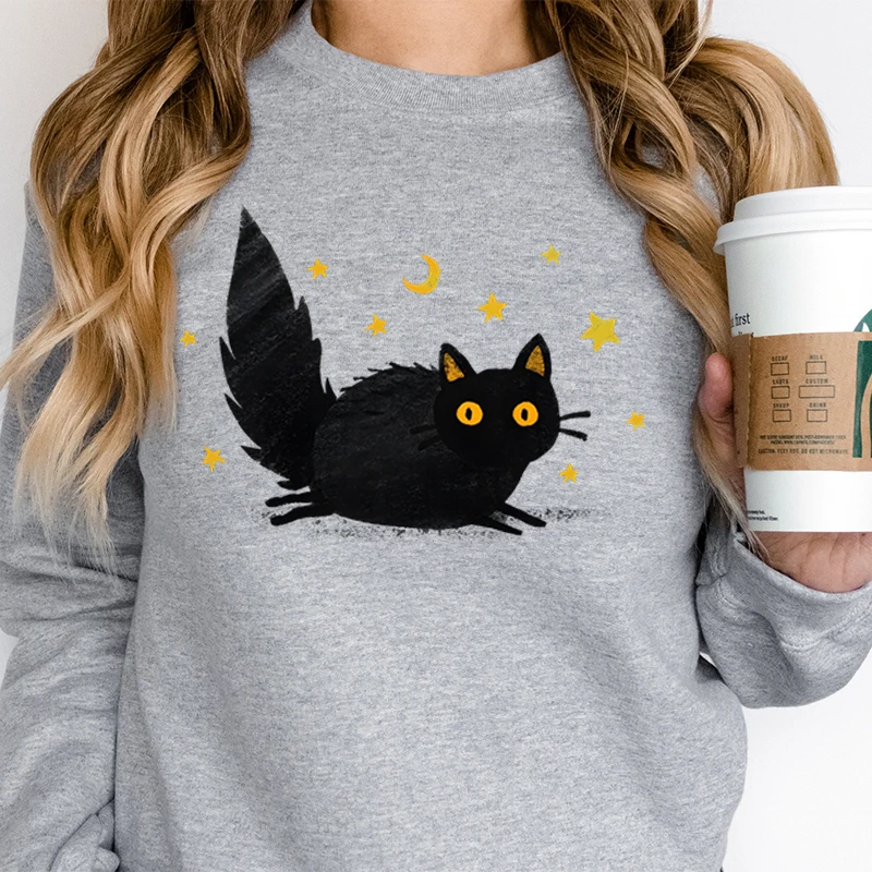 Felpa da donna alla moda con grafica gatto stelle e luna, occhi gialli, soffice gatto nero, tendenza, abbigliamento per ragazze, maglione gattino cartone animato