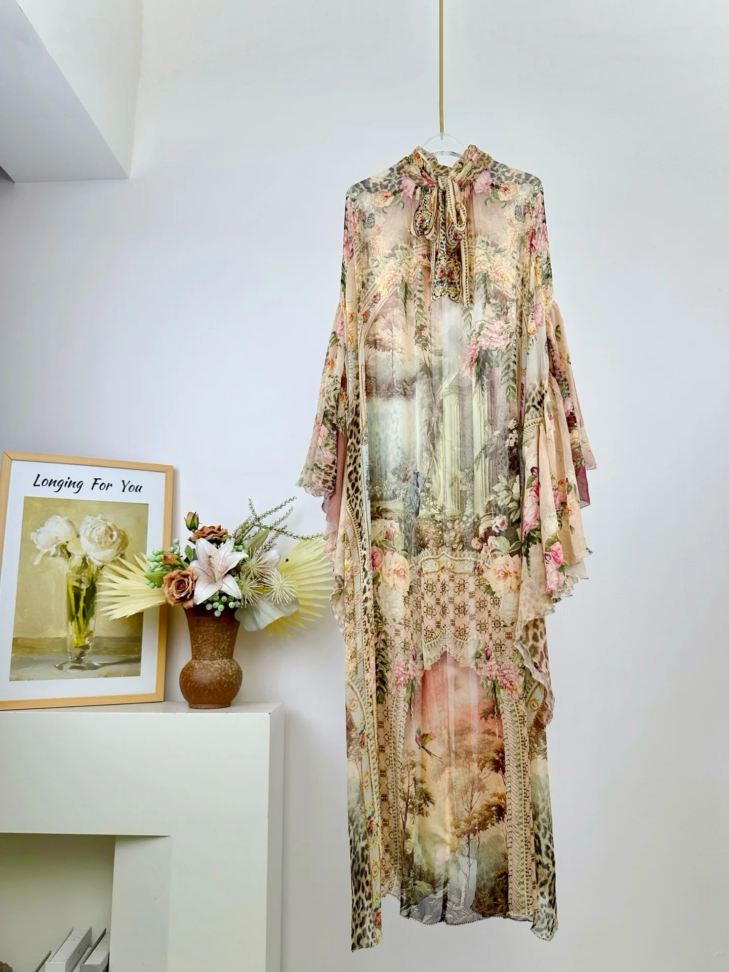 Damska sukienka z wysokim dekoltem, rękawami typu nietoperz, luźna, długa, jedwabna, w różowy wzór w panterkę.