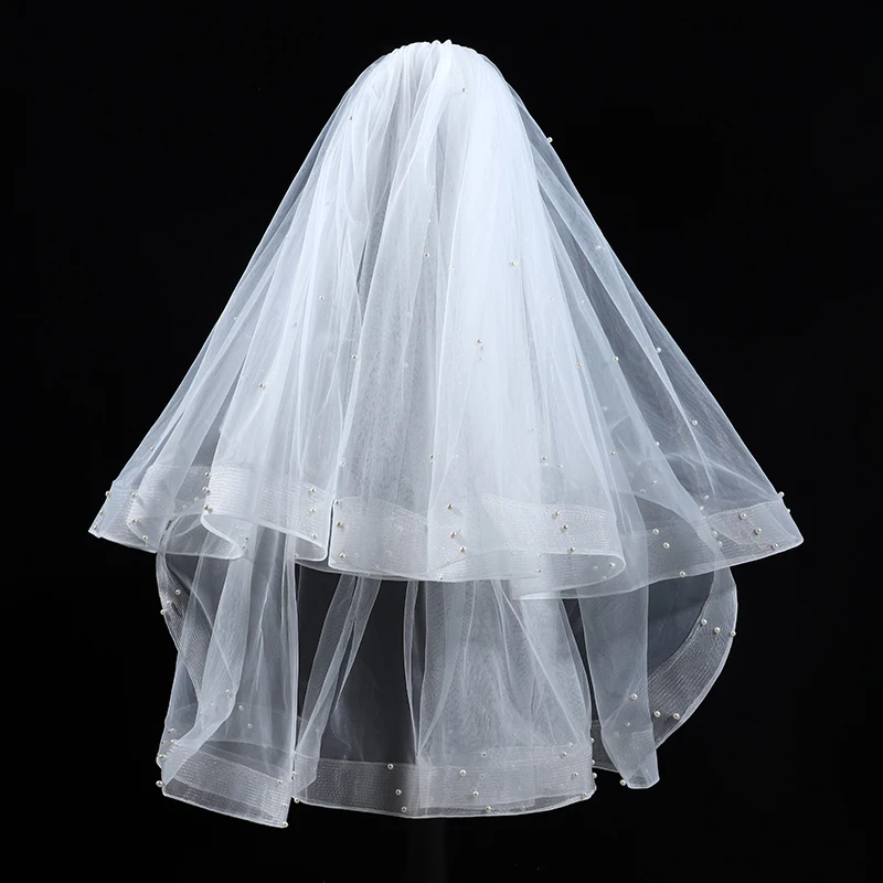 A white elegant bridal veil with a waist length veil adorned with simulated pearls, suitable for women's weddings