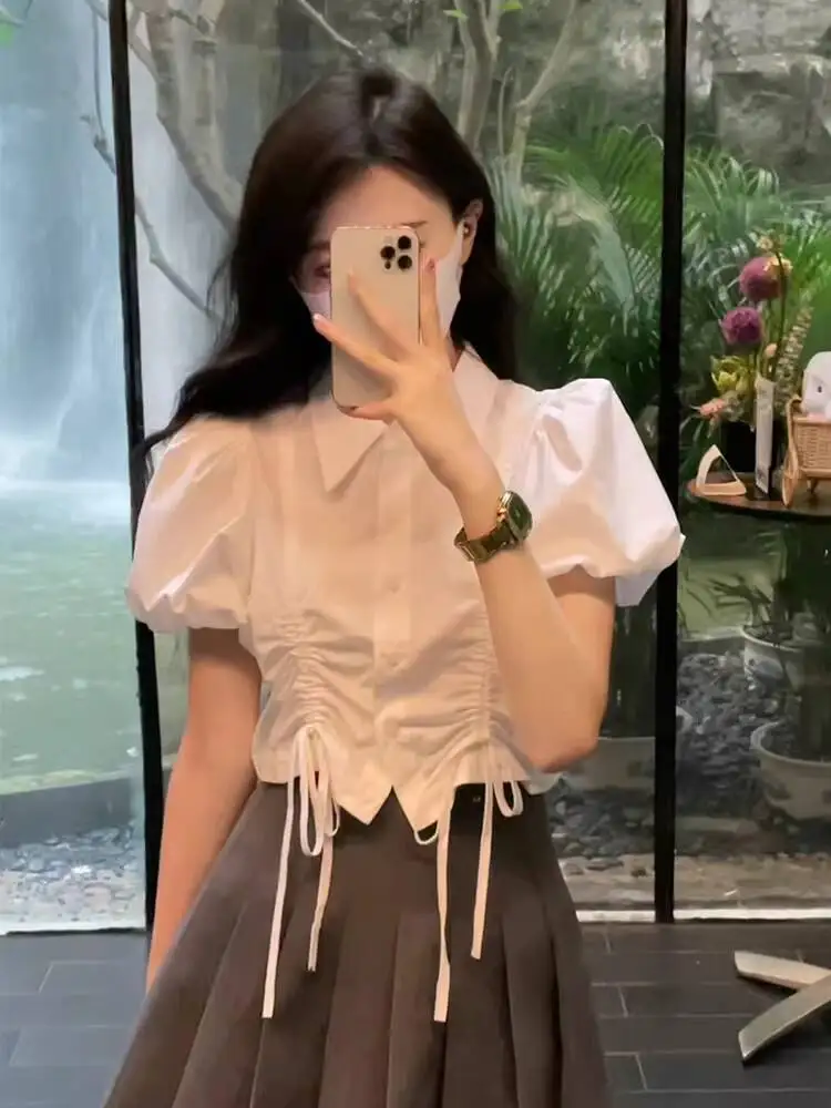 

Лето 2026: Новинка! Женская укороченная блузка в студенческом стиле с коротким рукавом, милым дизайном, воротником-рубашкой, пышными рукавами и сборками на шнуровке.