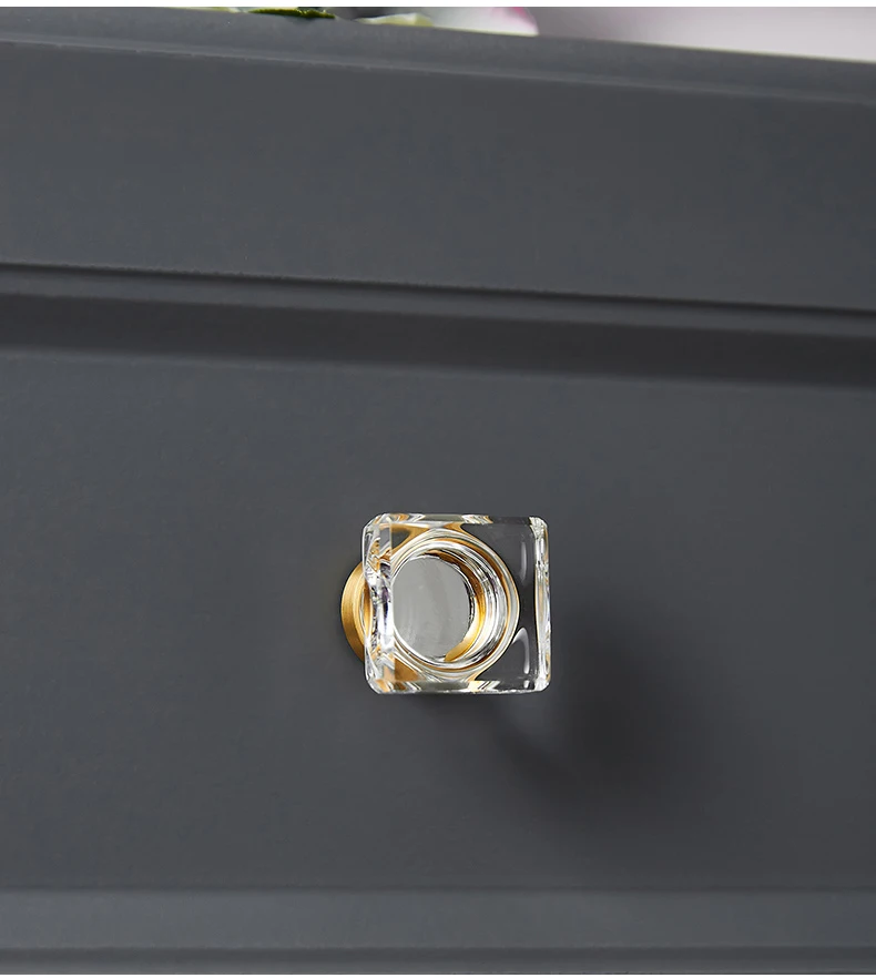 Square clear glass knob on a grey drawer