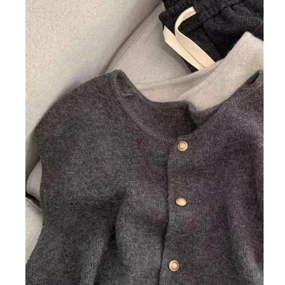 A gentle cashmere knitted vest with small golden buttons can be layered over a wool sleeveless vest top for autumn and winter