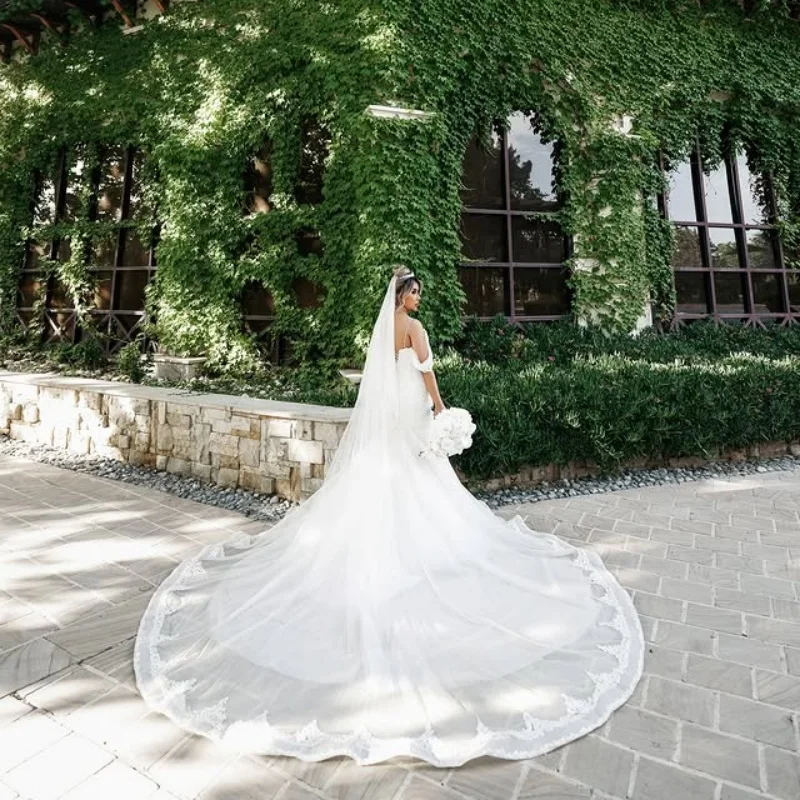 Abiti da sposa reali personalizzati con abito da ballo bianco brillante. Applicazione a strati di pizzo. Coda lunga realizzata Robe De