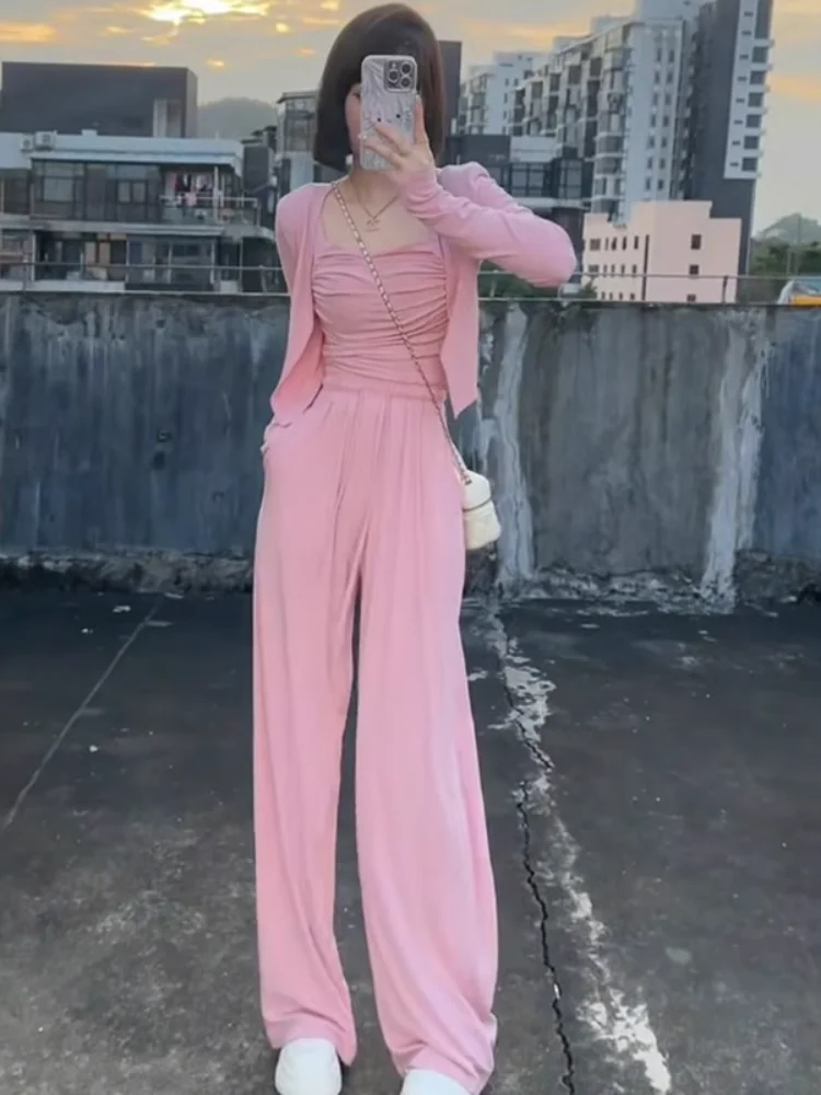 

Повседневный комплект из трех предметов: кардиган с длинными рукавами для защиты от солнца, широкие брюки на бретелях и топ. Модный женский ансамбль.