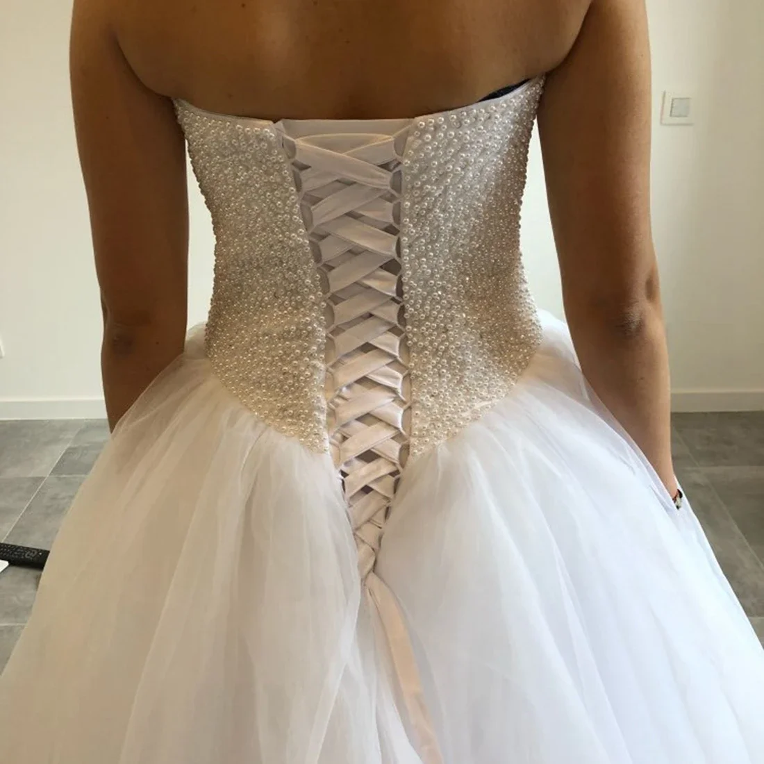 Elegante vestido de novia de tul con destino estilo bosque y cola de corte con cuentas hecha a mano