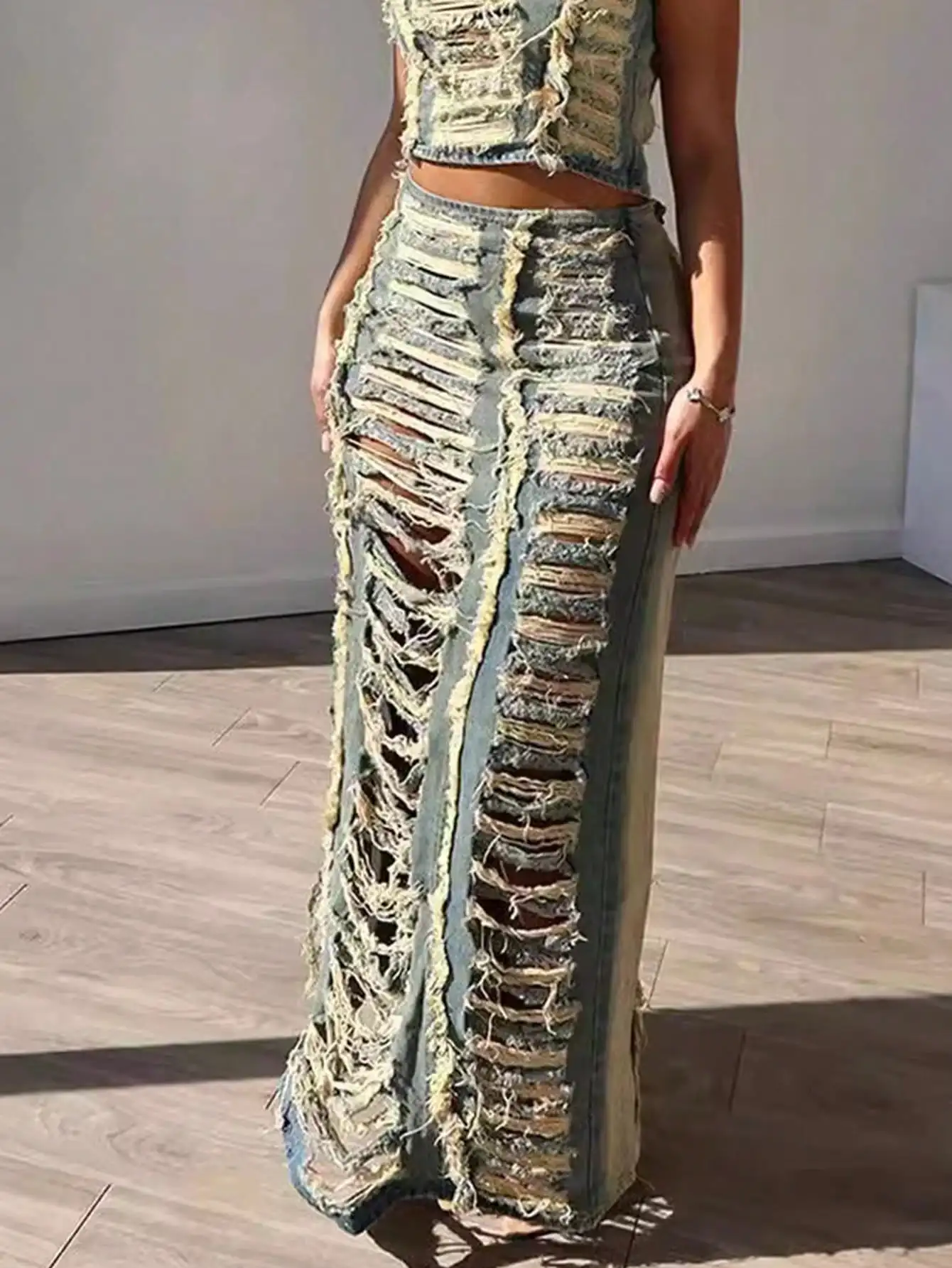 Gonna lunga in denim distressed con tagli cut-out, spacco alto e bordi sfrangiati grezzi