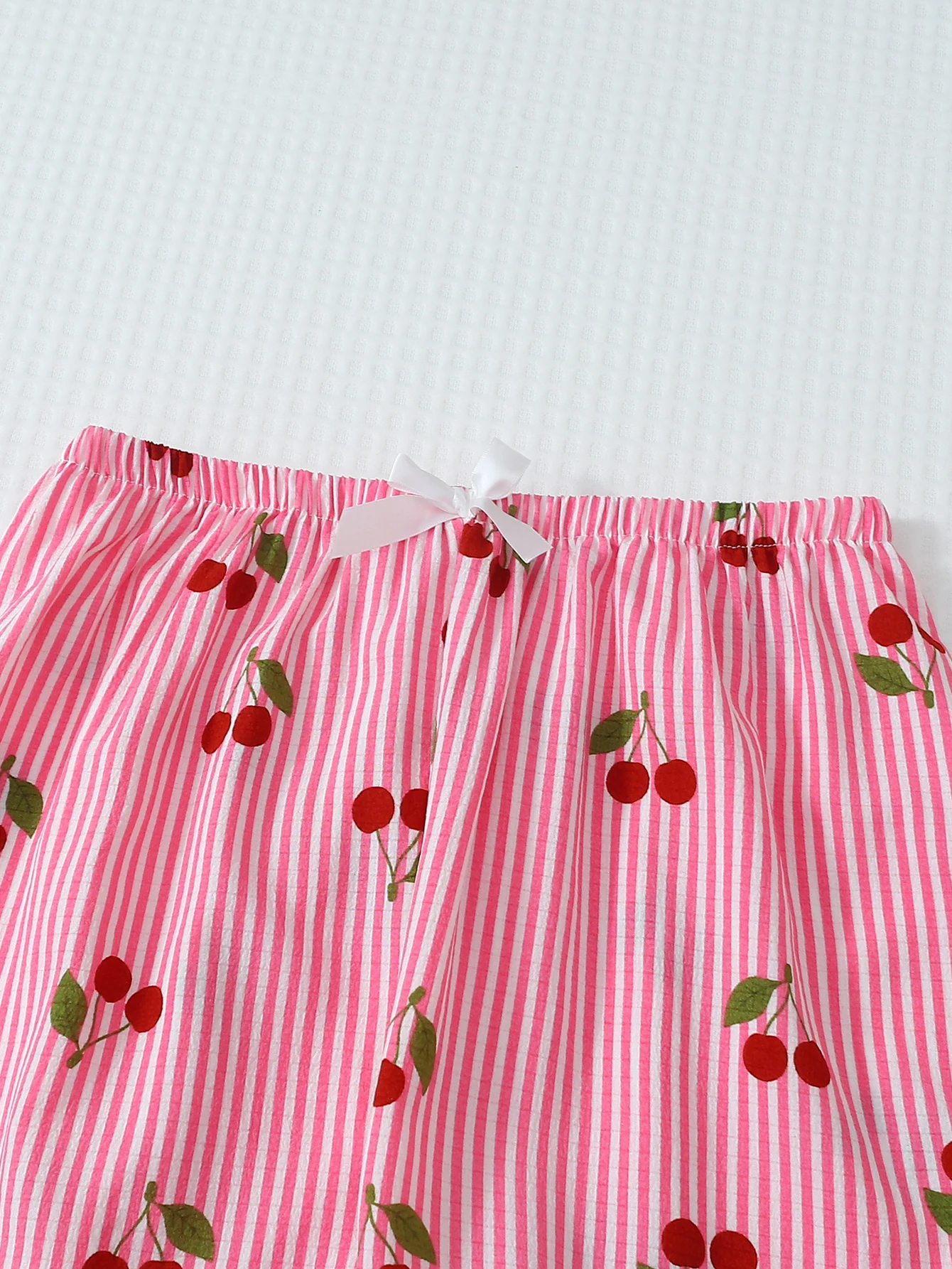 ツーピースの快適なピンクと白のストライプのチェリープリントのラペルボタンアップトップと蝶結びのロングパンツの女性用パジャマラウンジウェアセットは、家庭での使用に適しています。