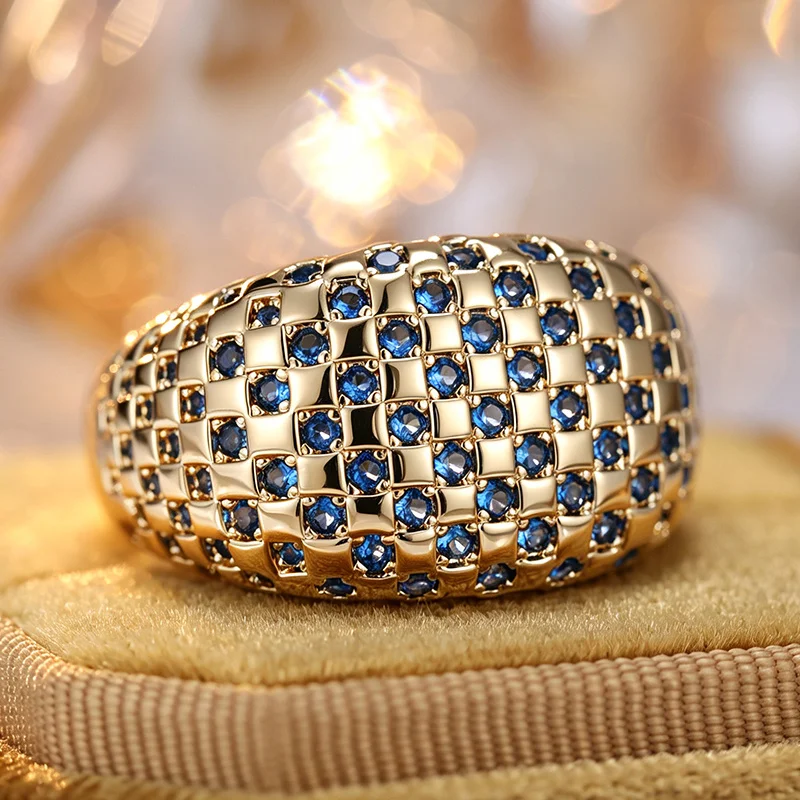 Exquisiter Luxusring für Damen in breiter Ausführung mit Gitterdesign und mehrschichtig eingesetzten hellblauen Zirkonen, glänzender Ring, Schmuckstück.