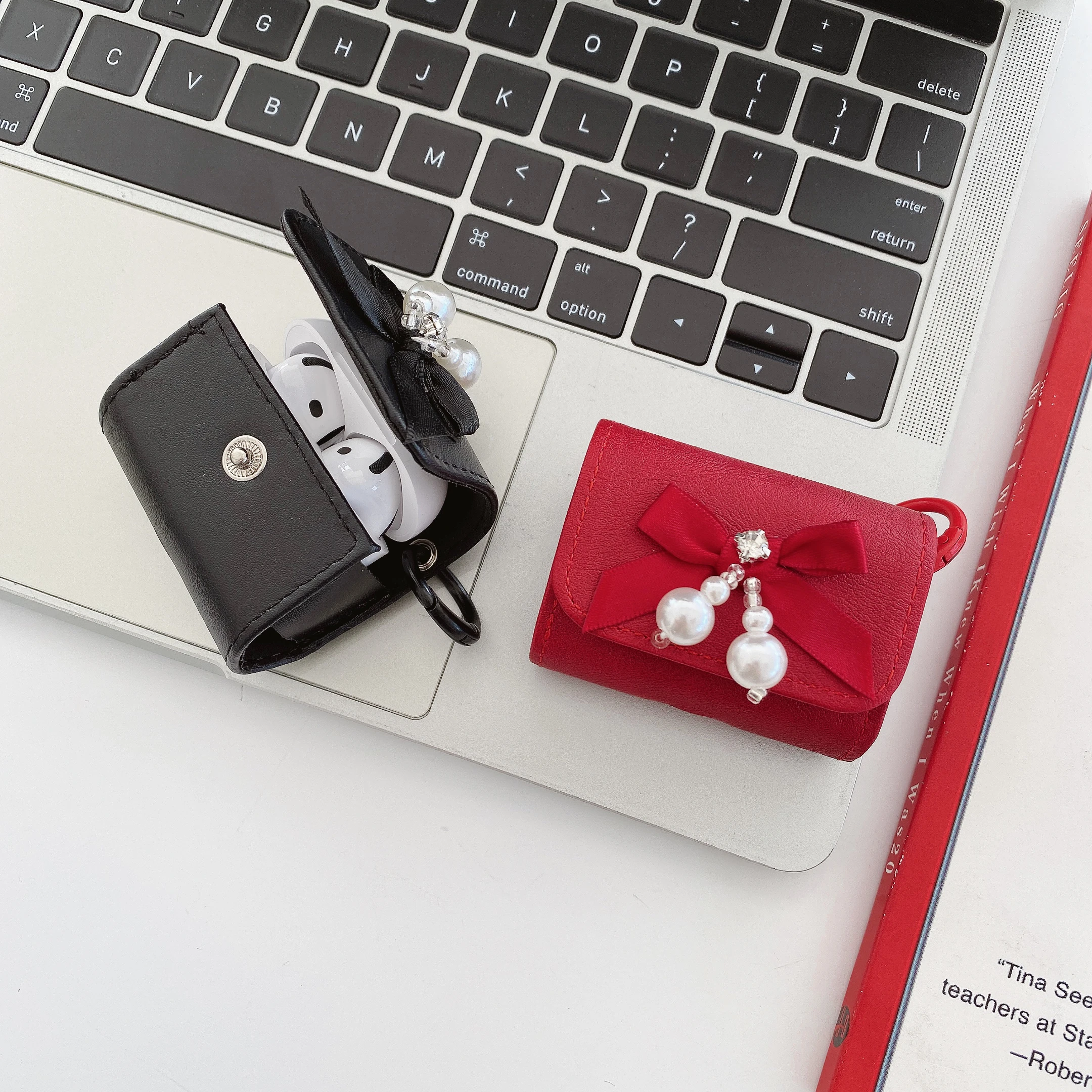 حافظة سماعات عصرية فاخرة من جلد البولي يوريثان مع عقدة على شكل فيونكة لؤلؤية كريستالية باللون الأسود والأحمر مع خطاف لأجهزة AirPods 1 2 3 4 Pro2 Pro 3